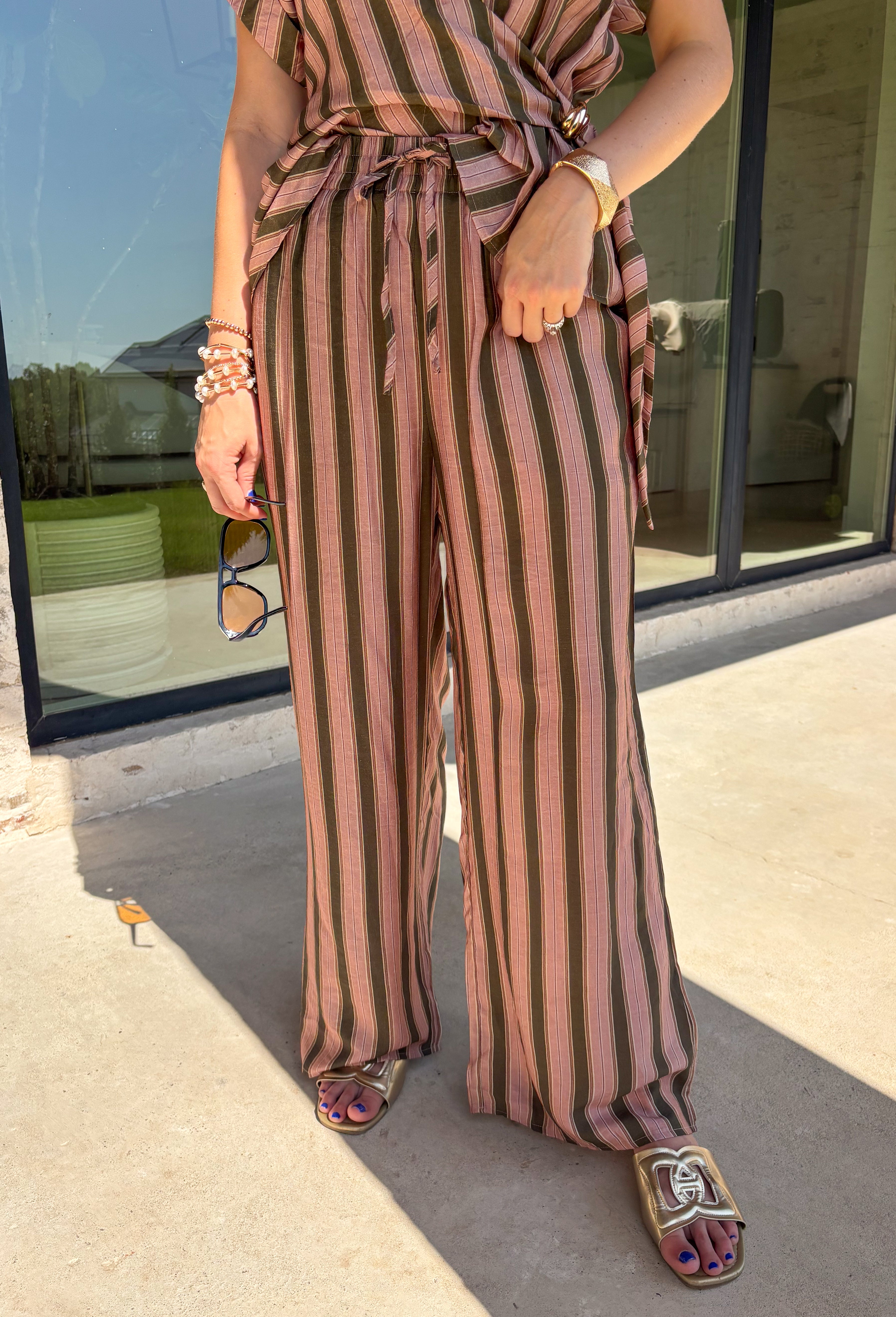 Easy, comfortable, and made for mixing and matching, these neutral stripe pants are a fall wardrobe win. The classic stripe print keeps them versatile, while the elasticated waistband and adjustable drawstring give them a relaxed feel that's ready for all-day wear. Convenient side pockets add an everyday touch that makes them just as practical as they are cute. 