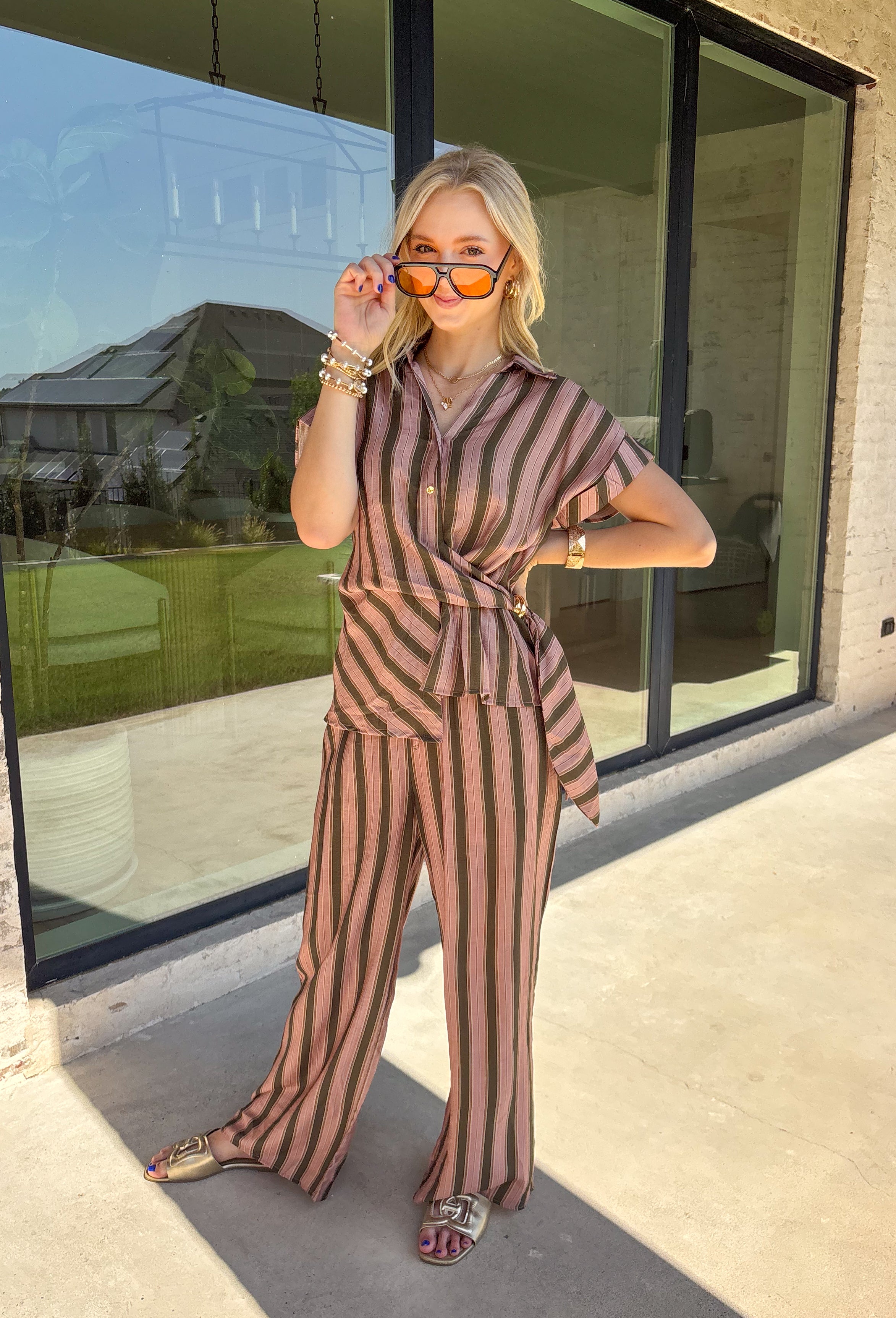 Warm neutral stripes make this Entro top an easy addition to your fall lineup. The button-front design gives it a classic feel, while the self-tie waist adds shape and a playful finishing touch. Short sleeves keep it lightweight enough for those warmer autumn days, making it an easy option for work, lunch plans, or a weekend out. Pair it with the matching pants for a coordinated two-piece set that does all the styling for you, or wear it individually with denim or solid bottoms for even more outfit options.