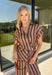 Warm neutral stripes make this Entro top an easy addition to your fall lineup. The button-front design gives it a classic feel, while the self-tie waist adds shape and a playful finishing touch. Short sleeves keep it lightweight enough for those warmer autumn days, making it an easy option for work, lunch plans, or a weekend out. Pair it with the matching pants for a coordinated two-piece set that does all the styling for you, or wear it individually with denim or solid bottoms for even more outfit options.