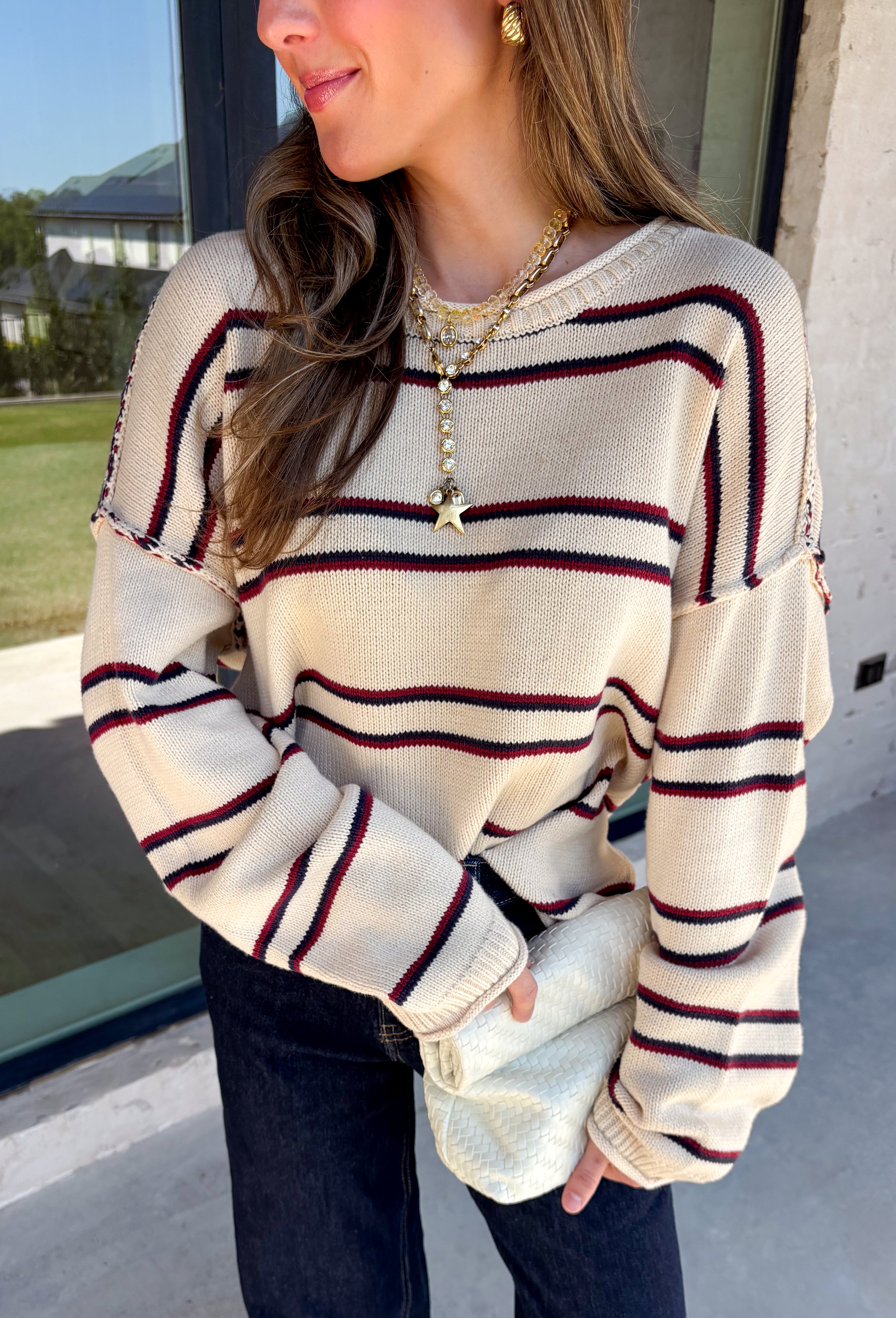 Nothing says cozy season quite like a classic striped sweater! This soft neutral knit is accented with timeless navy and burgundy stripes, creating the perfect color combination for fall. Exposed hems give it a relaxed, lived-in feel, while the ribbed neckline, cuffs, and hem add a polished finish. Whether you're headed to a football game, a weekend getaway, or simply enjoying a crisp autumn day, this cozy sweater is one you'll love reaching for.