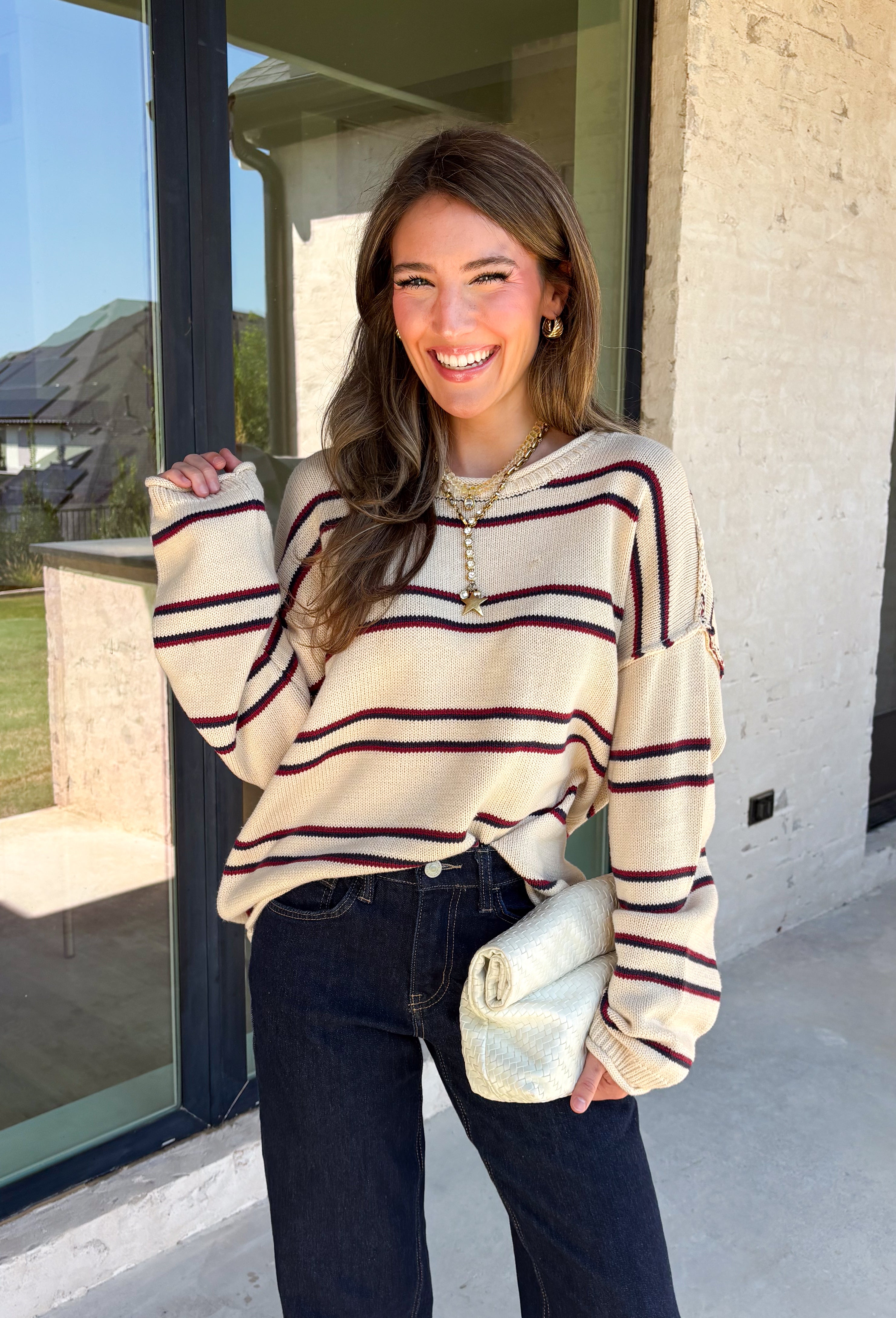 Nothing says cozy season quite like a classic striped sweater! This soft neutral knit is accented with timeless navy and burgundy stripes, creating the perfect color combination for fall. Exposed hems give it a relaxed, lived-in feel, while the ribbed neckline, cuffs, and hem add a polished finish. Whether you're headed to a football game, a weekend getaway, or simply enjoying a crisp autumn day, this cozy sweater is one you'll love reaching for.