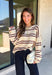 Nothing says cozy season quite like a classic striped sweater! This soft neutral knit is accented with timeless navy and burgundy stripes, creating the perfect color combination for fall. Exposed hems give it a relaxed, lived-in feel, while the ribbed neckline, cuffs, and hem add a polished finish. Whether you're headed to a football game, a weekend getaway, or simply enjoying a crisp autumn day, this cozy sweater is one you'll love reaching for.