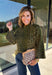 Bring a bold touch to your fall wardrobe with this cozy leopard sweater from Entro. Featuring a rich olive backdrop with a timeless leopard print, this effortlessly stylish knit is the perfect blend of classic and fun. The round neckline creates an easy, everyday silhouette, while the soft, cozy knit keeps you warm and comfortable on crisp autumn days. Whether you're headed to brunch, running errands, or enjoying a weekend getaway, this sweater is an easy favorite you'll wear on repeat.