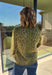 Bring a bold touch to your fall wardrobe with this cozy leopard sweater from Entro. Featuring a rich olive backdrop with a timeless leopard print, this effortlessly stylish knit is the perfect blend of classic and fun. The round neckline creates an easy, everyday silhouette, while the soft, cozy knit keeps you warm and comfortable on crisp autumn days. Whether you're headed to brunch, running errands, or enjoying a weekend getaway, this sweater is an easy favorite you'll wear on repeat.