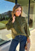 Bring a bold touch to your fall wardrobe with this cozy leopard sweater from Entro. Featuring a rich olive backdrop with a timeless leopard print, this effortlessly stylish knit is the perfect blend of classic and fun. The round neckline creates an easy, everyday silhouette, while the soft, cozy knit keeps you warm and comfortable on crisp autumn days. Whether you're headed to brunch, running errands, or enjoying a weekend getaway, this sweater is an easy favorite you'll wear on repeat.