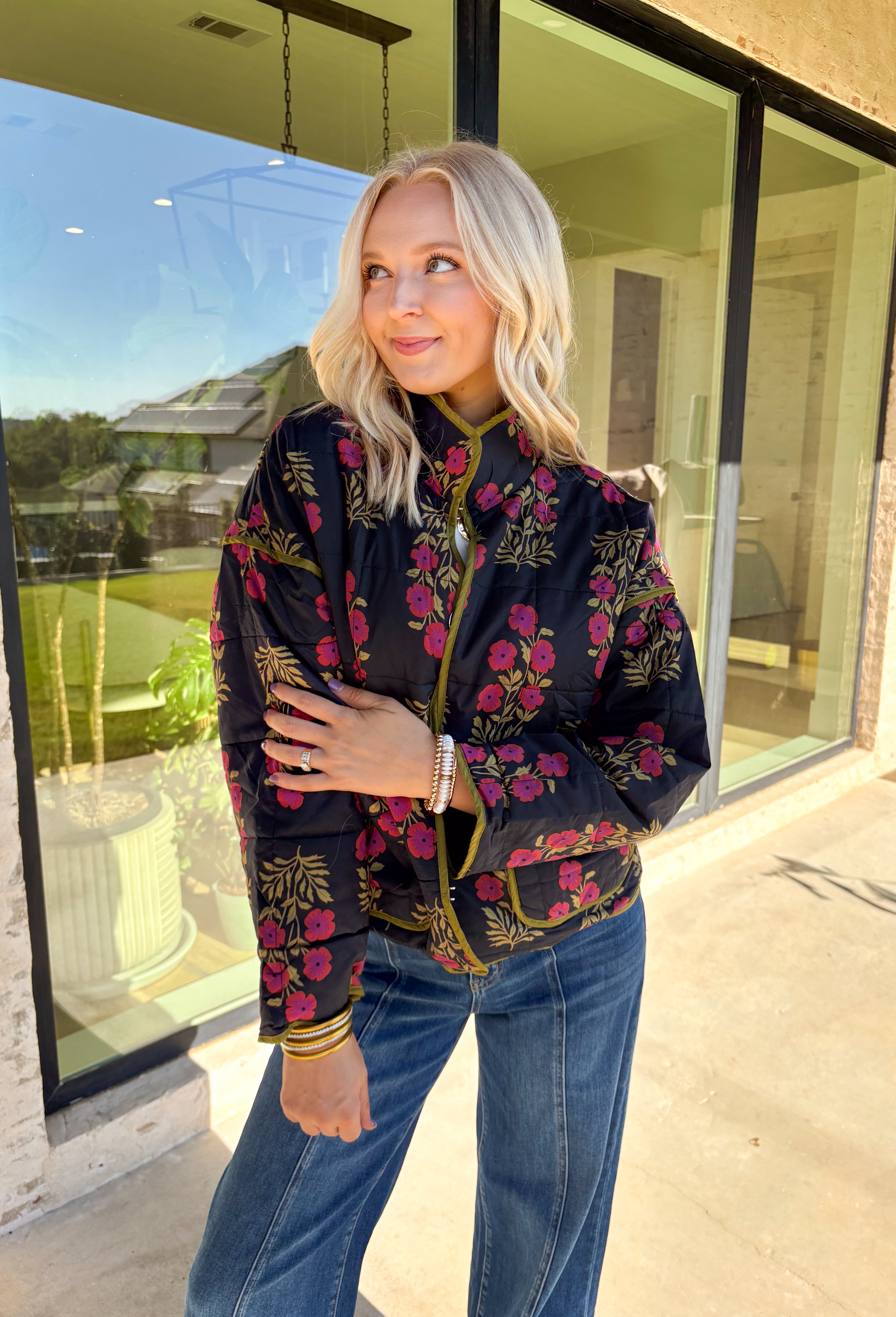 Wrap up in seasonal style with this black quilted jacket featuring a rich botanical print in olive and burgundy tones. Contrast binding highlights the edges for a polished finish, while front patch pockets add both function and charm. The hook-and-eye closure keeps the silhouette clean and simple, and the all-cotton design makes it cozy yet breathable for cool fall days. Whether layered over a sweater or paired with a casual tee, this jacket is a statement piece you’ll wear on repeat.