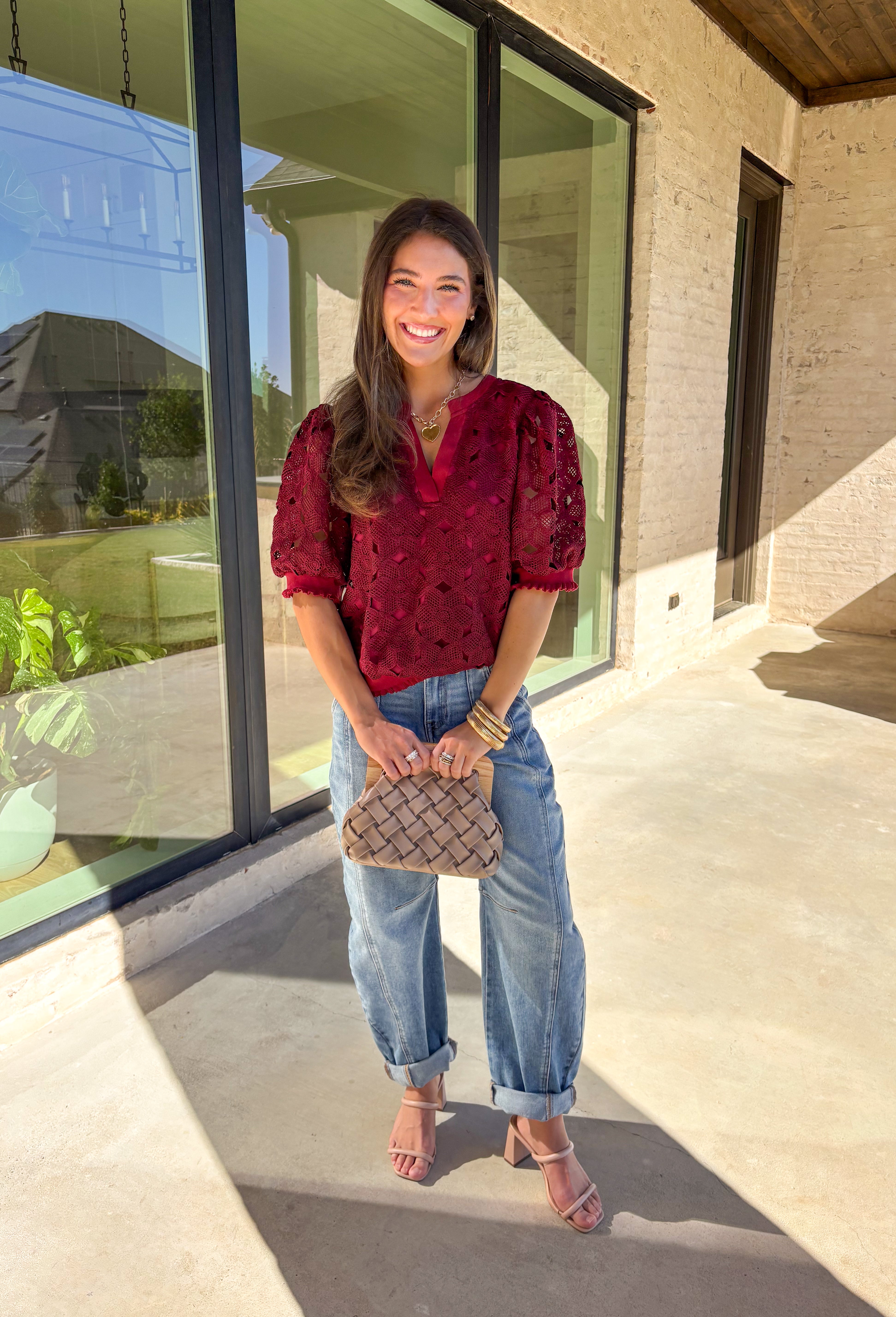 Romantic and feminine, this burgundy crochet lace overlay top by Voy is the perfect piece to elevate your fall wardrobe. The delicate lace design gives it beautiful texture, while the short sleeves and v-neckline add an effortless touch. Lettuce trim along the sleeves and hemline adds a soft, finished detail that keeps the look both classic and fresh.