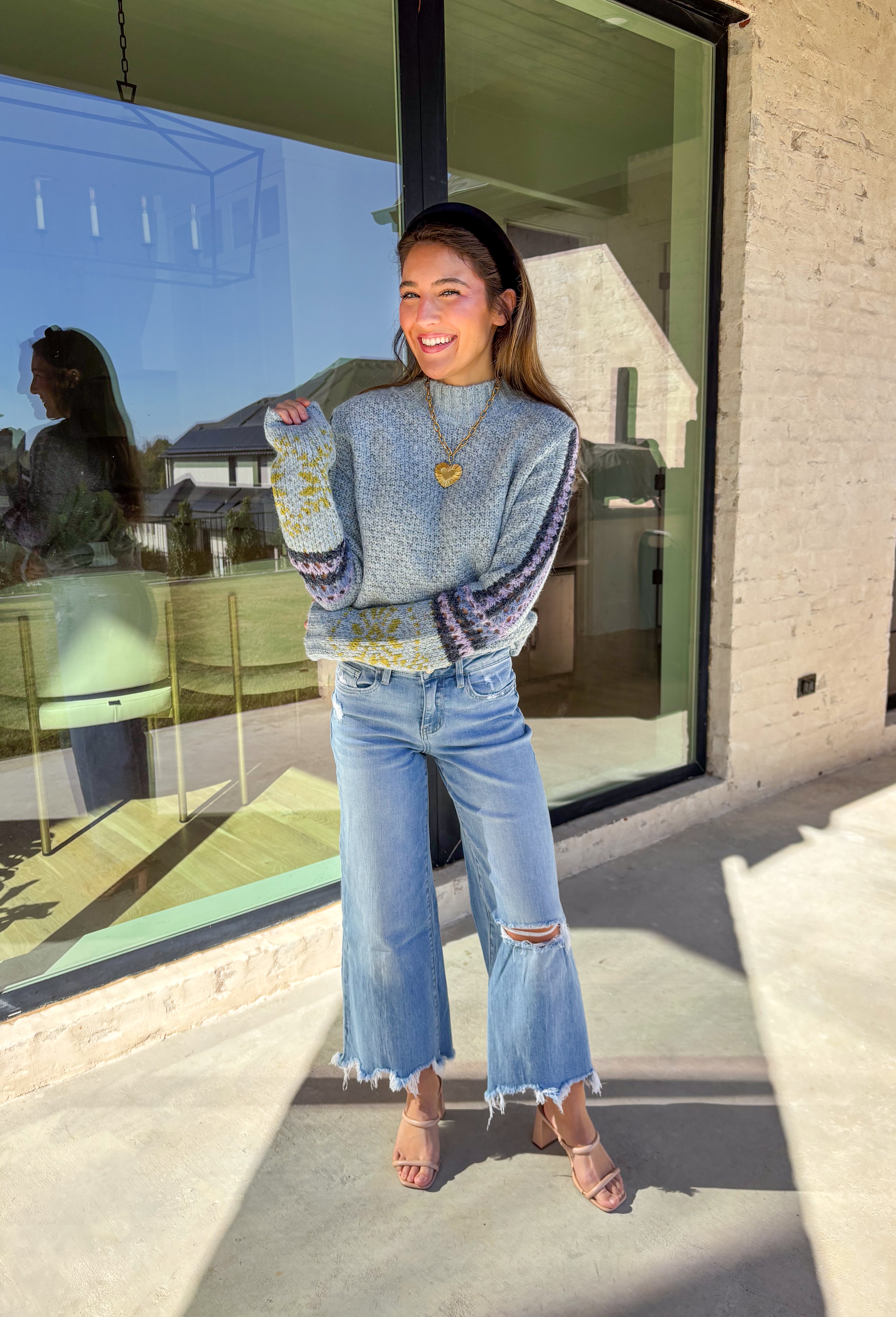 Bring a little color to chilly days with this cozy light blue knit sweater by Mystree. The mock neck design keeps you warm, while the abstract print sleeves—featuring shades of navy, light purple, and green—add a playful, modern twist. Soft, warm, and stylish, this sweater is an easy pick for staying cozy and cute all season long.