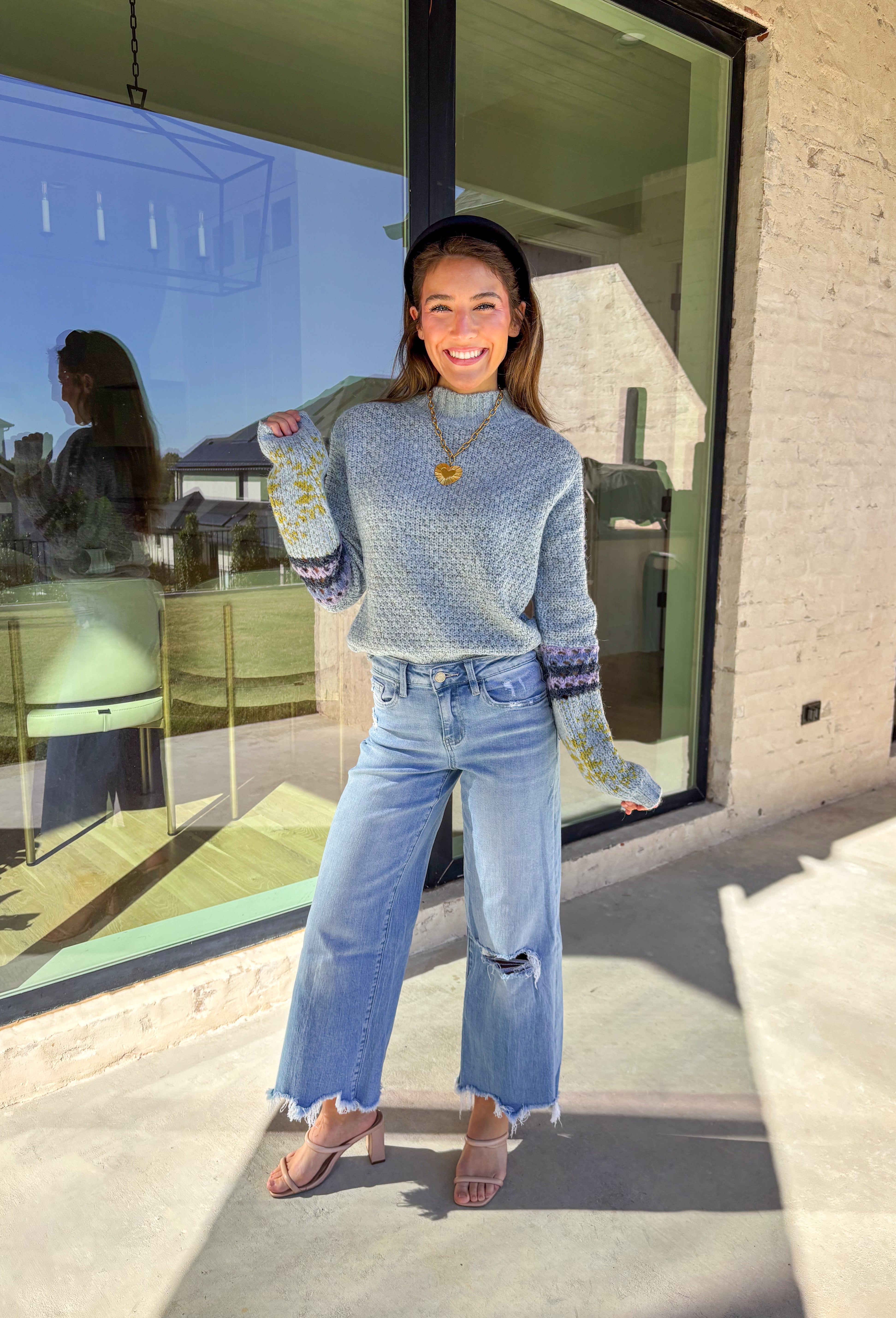Bring a little color to chilly days with this cozy light blue knit sweater by Mystree. The mock neck design keeps you warm, while the abstract print sleeves—featuring shades of navy, light purple, and green—add a playful, modern twist. Soft, warm, and stylish, this sweater is an easy pick for staying cozy and cute all season long.