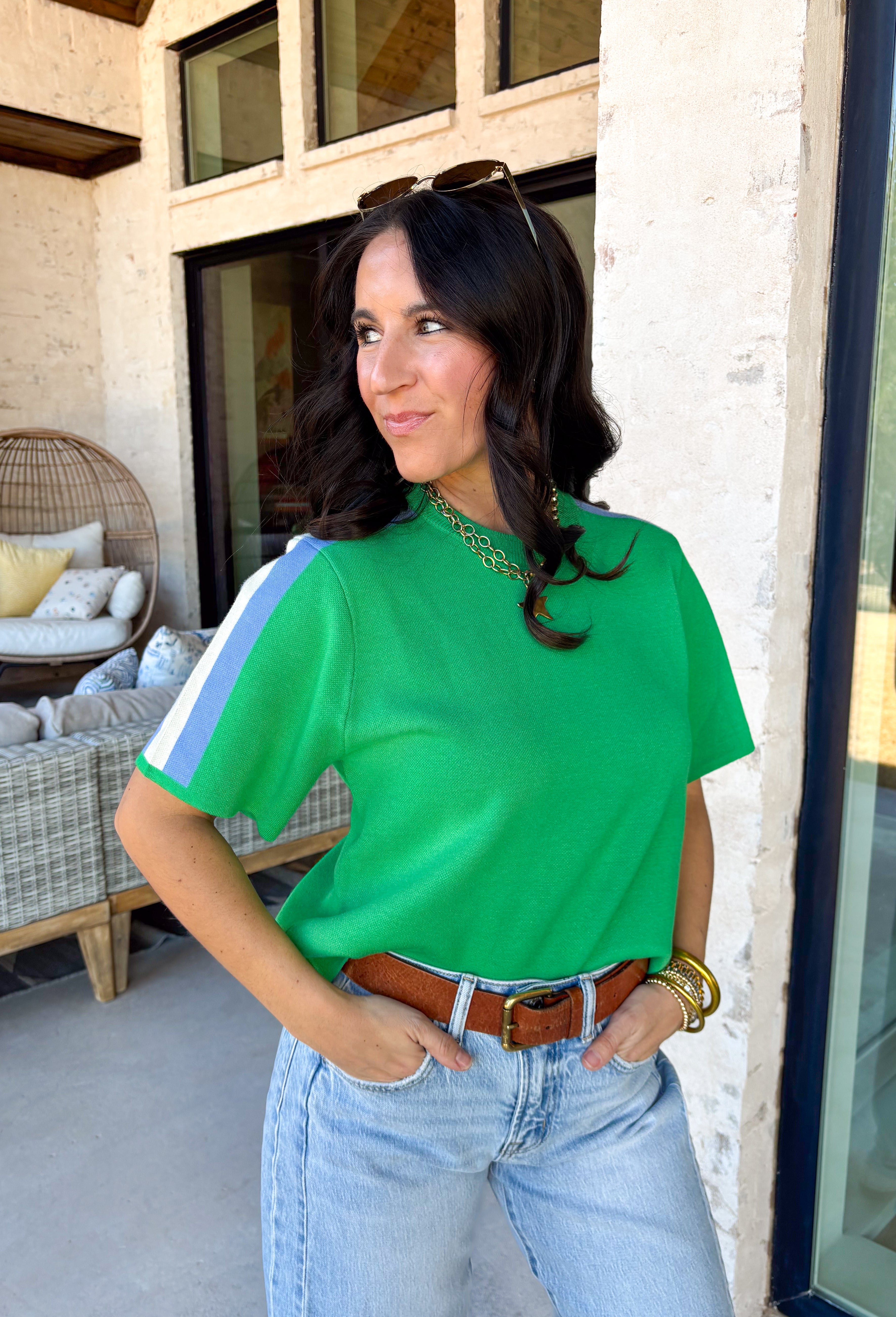 Sporty meets spring in this green short sleeve knit top by Entro. Designed with a soft, lightweight knit feel, it features a bold blue and white contrast stripe down the sides for a fun pop of color and a flattering, elongating look. Easy to dress up or down, this top is perfect for casual spring days when you still want something polished and comfortable.