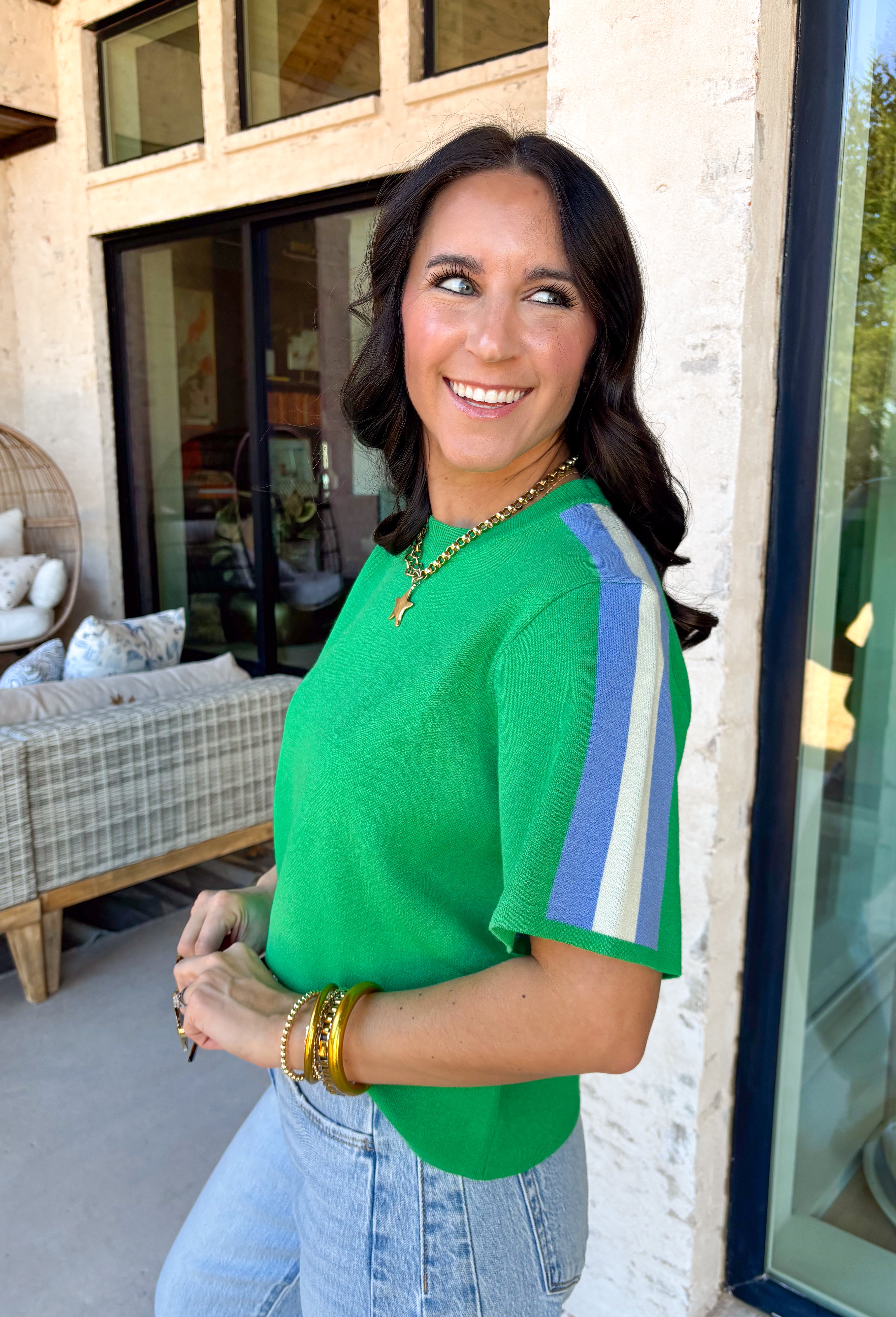 Sporty meets spring in this green short sleeve knit top by Entro. Designed with a soft, lightweight knit feel, it features a bold blue and white contrast stripe down the sides for a fun pop of color and a flattering, elongating look. Easy to dress up or down, this top is perfect for casual spring days when you still want something polished and comfortable.