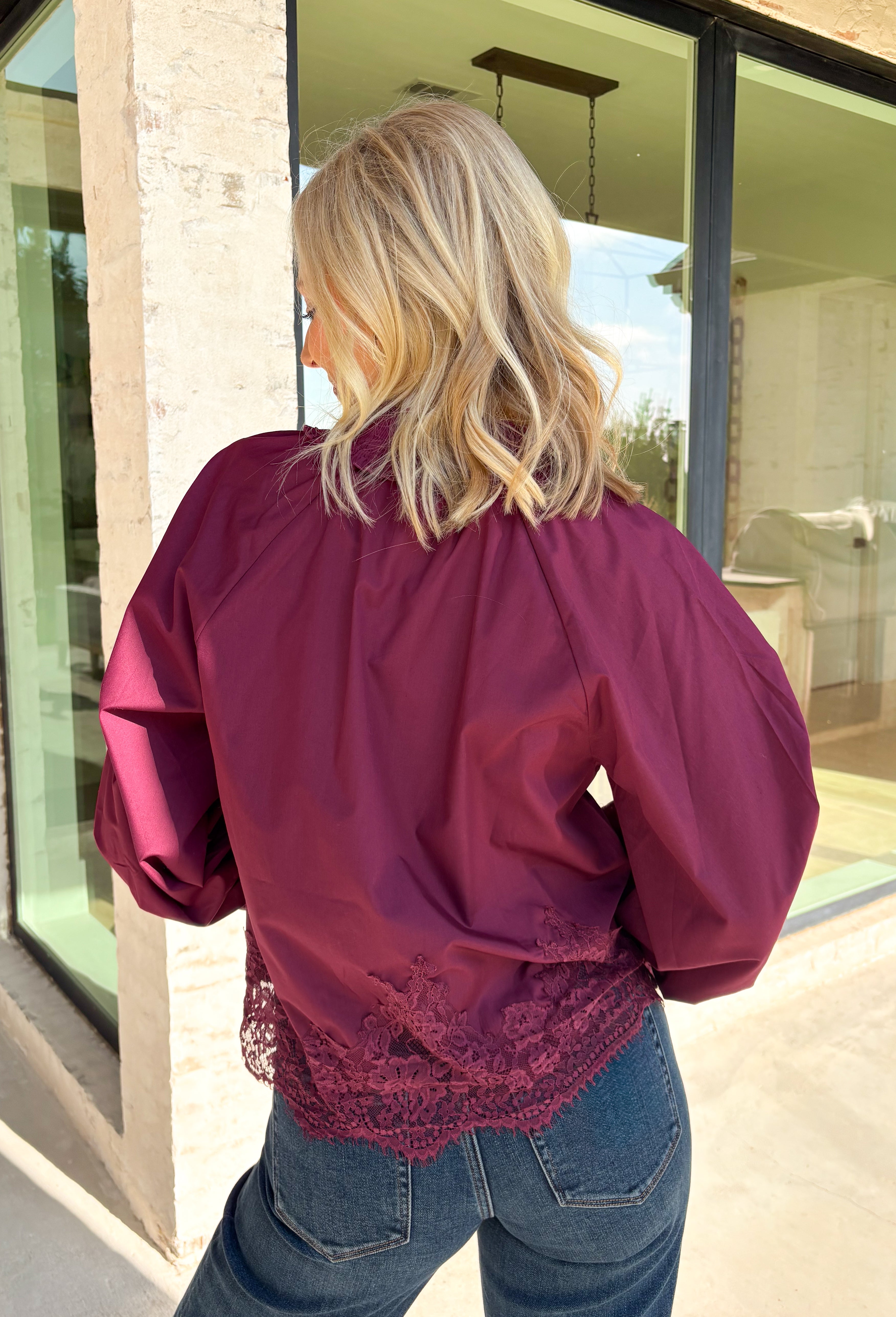 Bring a touch of romantic charm to your fall wardrobe with this beautifully detailed blouse from Entro. Designed in a rich burgundy hue, this feminine top features a softly smocked neckline with a delicate front tie for an effortlessly graceful look. The long sleeves are finished with smocked cuffs and lace trim, while the lace hem adds an elegant finishing touch. 