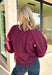 Bring a touch of romantic charm to your fall wardrobe with this beautifully detailed blouse from Entro. Designed in a rich burgundy hue, this feminine top features a softly smocked neckline with a delicate front tie for an effortlessly graceful look. The long sleeves are finished with smocked cuffs and lace trim, while the lace hem adds an elegant finishing touch. 