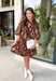 Capture the beauty of the season in this effortlessly feminine dress from Entro. Designed with a rich brown backdrop and a fall-inspired floral print with delicate leaf-like details, this charming dress is perfect for everything from brunch dates to seasonal celebrations. The flattering v-neckline features sweet tie details at the neck and bust, while decorative front buttons add timeless appeal. 