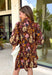 Capture the beauty of the season in this effortlessly feminine dress from Entro. Designed with a rich brown backdrop and a fall-inspired floral print with delicate leaf-like details, this charming dress is perfect for everything from brunch dates to seasonal celebrations. The flattering v-neckline features sweet tie details at the neck and bust, while decorative front buttons add timeless appeal. 