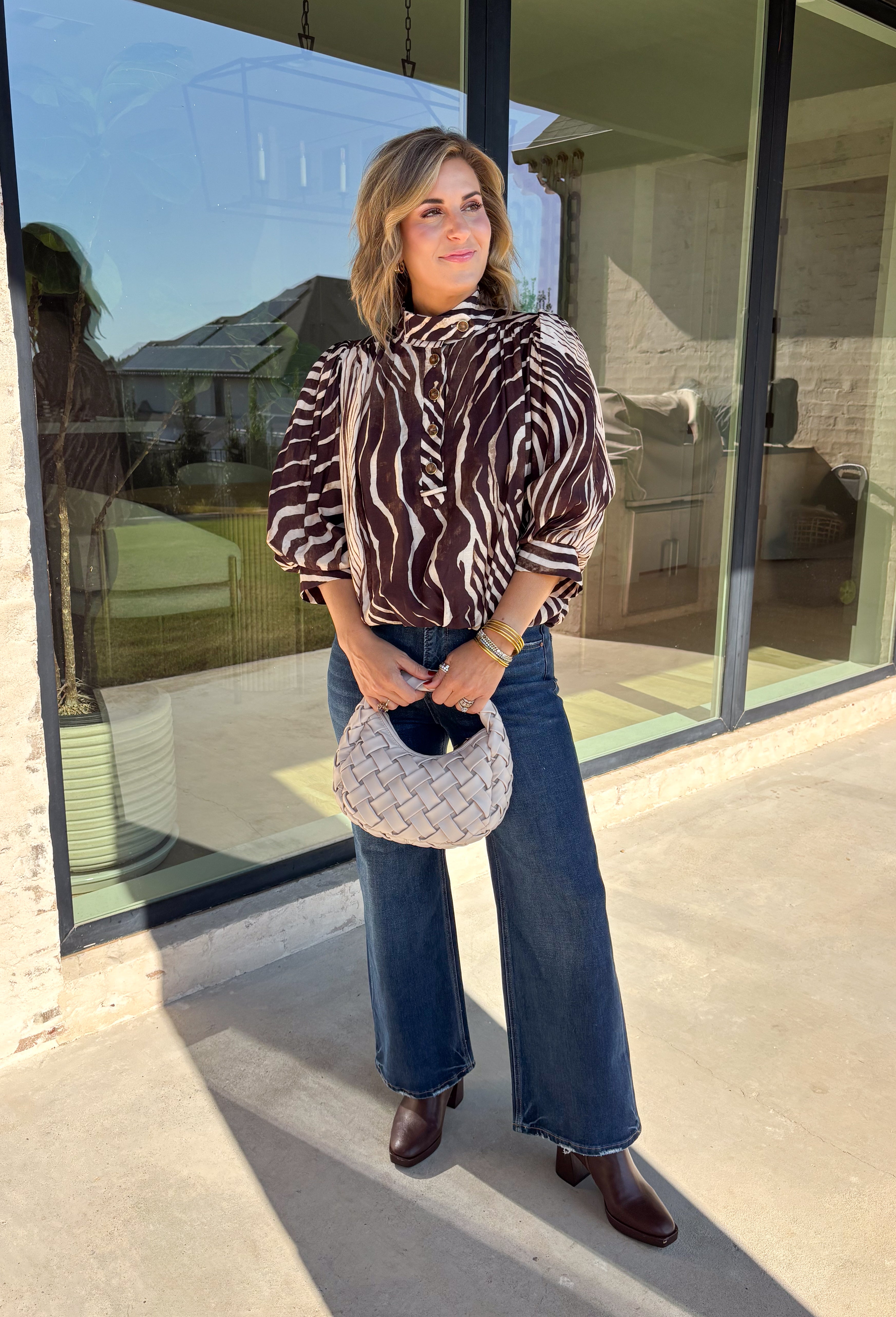 Neutral gets a little wild with this brown and cream zebra print blouse from Entro. The warm color combination makes the statement print easy to style while fitting perfectly into the transition from fall into winter. A stand collar and partial button-front closure give the lightweight silhouette a classic touch, while gathered detailing at the shoulders and back adds shape and movement.