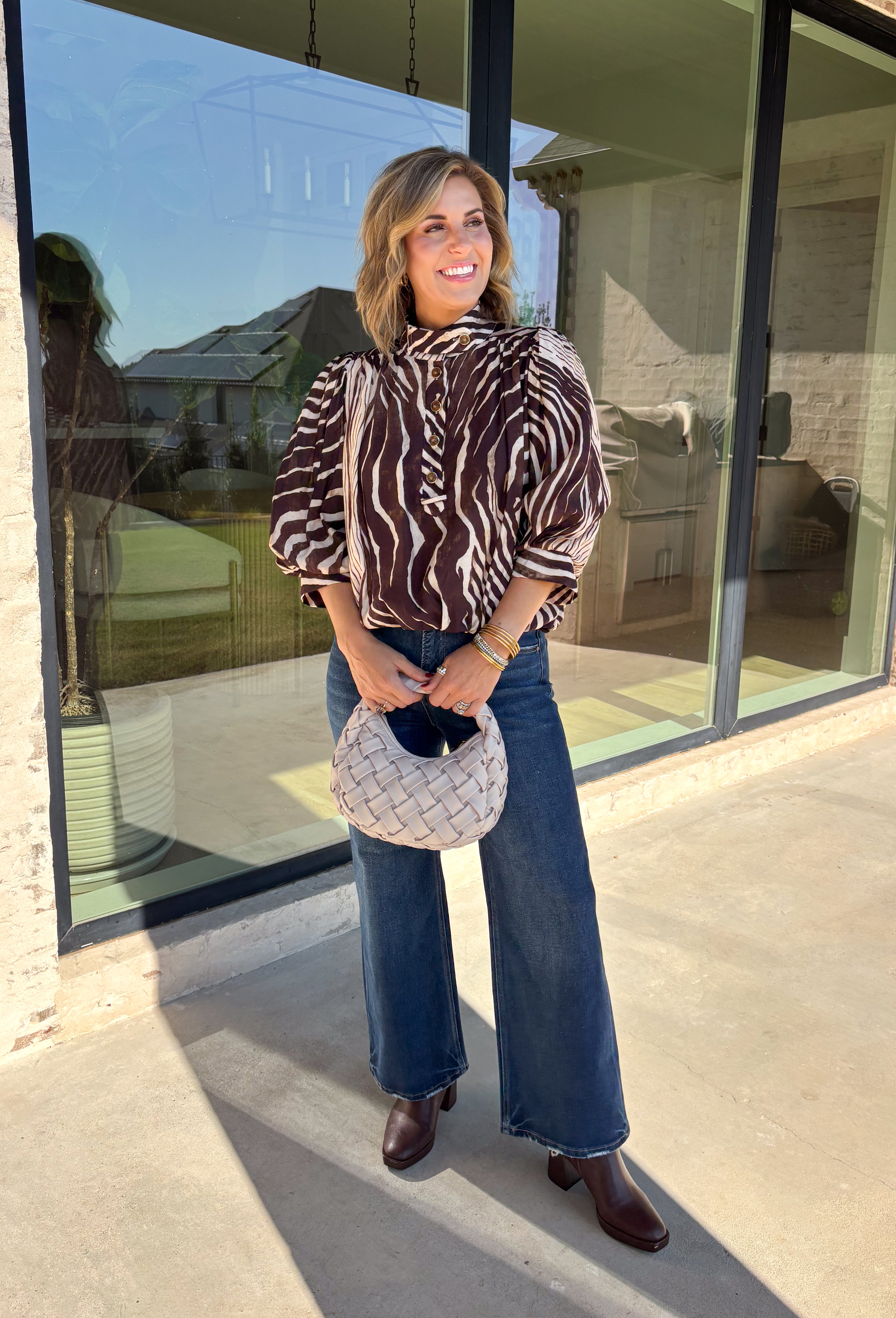 Neutral gets a little wild with this brown and cream zebra print blouse from Entro. The warm color combination makes the statement print easy to style while fitting perfectly into the transition from fall into winter. A stand collar and partial button-front closure give the lightweight silhouette a classic touch, while gathered detailing at the shoulders and back adds shape and movement.