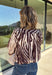 Neutral gets a little wild with this brown and cream zebra print blouse from Entro. The warm color combination makes the statement print easy to style while fitting perfectly into the transition from fall into winter. A stand collar and partial button-front closure give the lightweight silhouette a classic touch, while gathered detailing at the shoulders and back adds shape and movement.