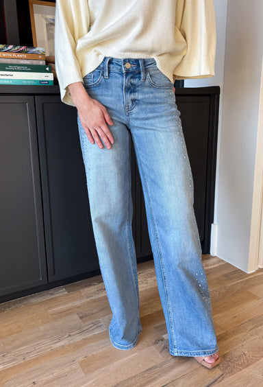 Statement denim, but still totally wearable. These medium wash wide leg jeans by Vervet feature a flattering high-rise fit with silver rhinestone detailing running along the sides of each leg for just the right amount of sparkle. The wide leg silhouette feels fresh and effortless for spring, while the longer inseam gives them a sleek, elongating look. Dress them up or keep them casual—either way, these jeans are made to stand out.