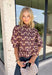 Soft, feminine, and full of seasonal charm, this floral blouse is an effortless addition to your fall wardrobe. Designed with a beautiful blush backdrop and a rich burgundy and tan floral print, this top brings together warm autumn hues in a timeless silhouette. The button-front design adds classic appeal, while the ruffle hem creates a flattering, feminine finish. Gathered detailing at the back yoke gives this blouse a relaxed, flowy fit that's perfect for everything from workdays to weekend outings.
