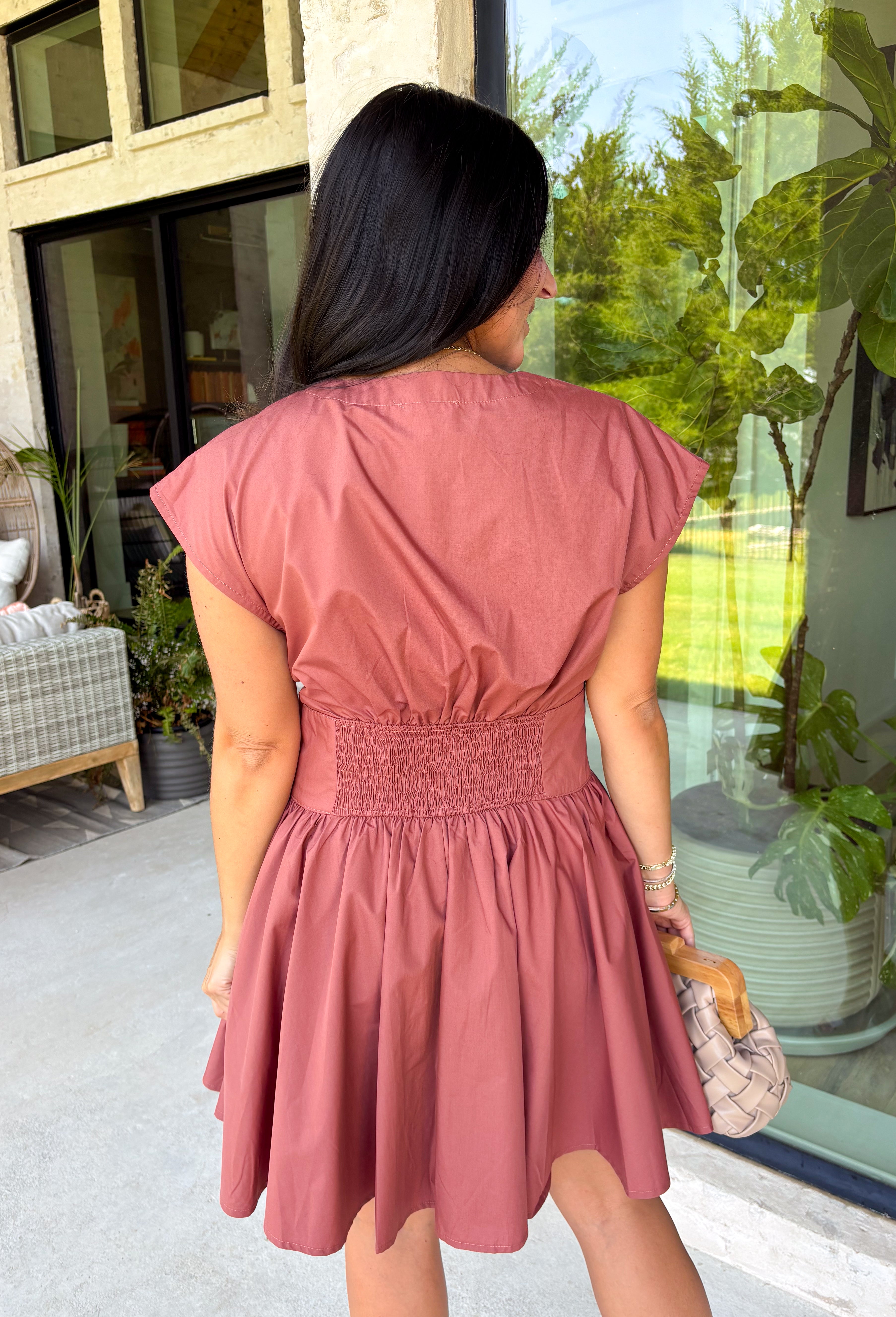 Easy, timeless, and effortlessly flattering, this clay dress is ready for all your favorite fall moments! The warm clay hue pairs beautifully with the season, while the v-neckline and button front create a classic, polished look. Gathered detailing at the waist and a smocked back offer a comfortable, figure-flattering fit you'll love wearing from day to night. 