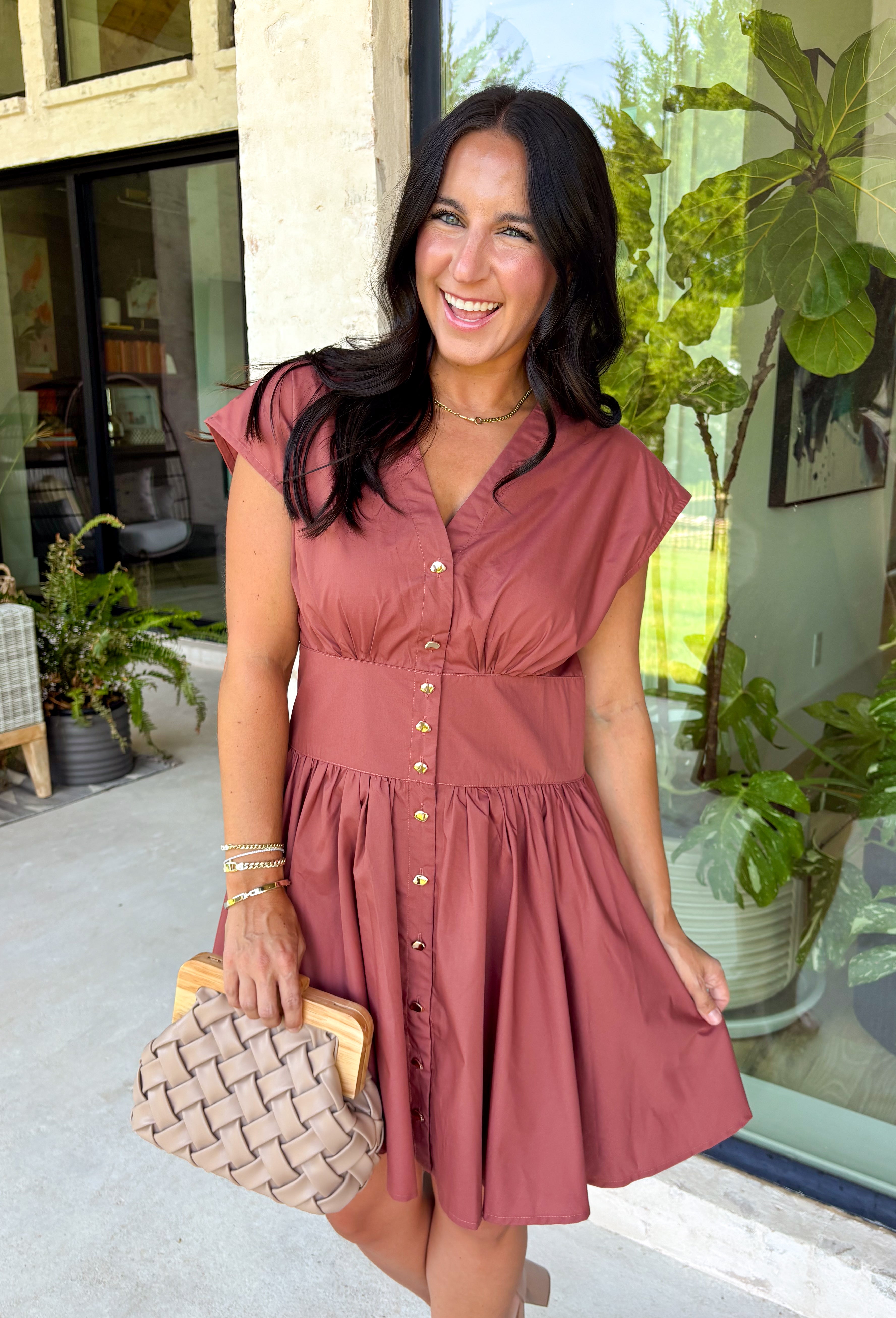 Easy, timeless, and effortlessly flattering, this clay dress is ready for all your favorite fall moments! The warm clay hue pairs beautifully with the season, while the v-neckline and button front create a classic, polished look. Gathered detailing at the waist and a smocked back offer a comfortable, figure-flattering fit you'll love wearing from day to night. 