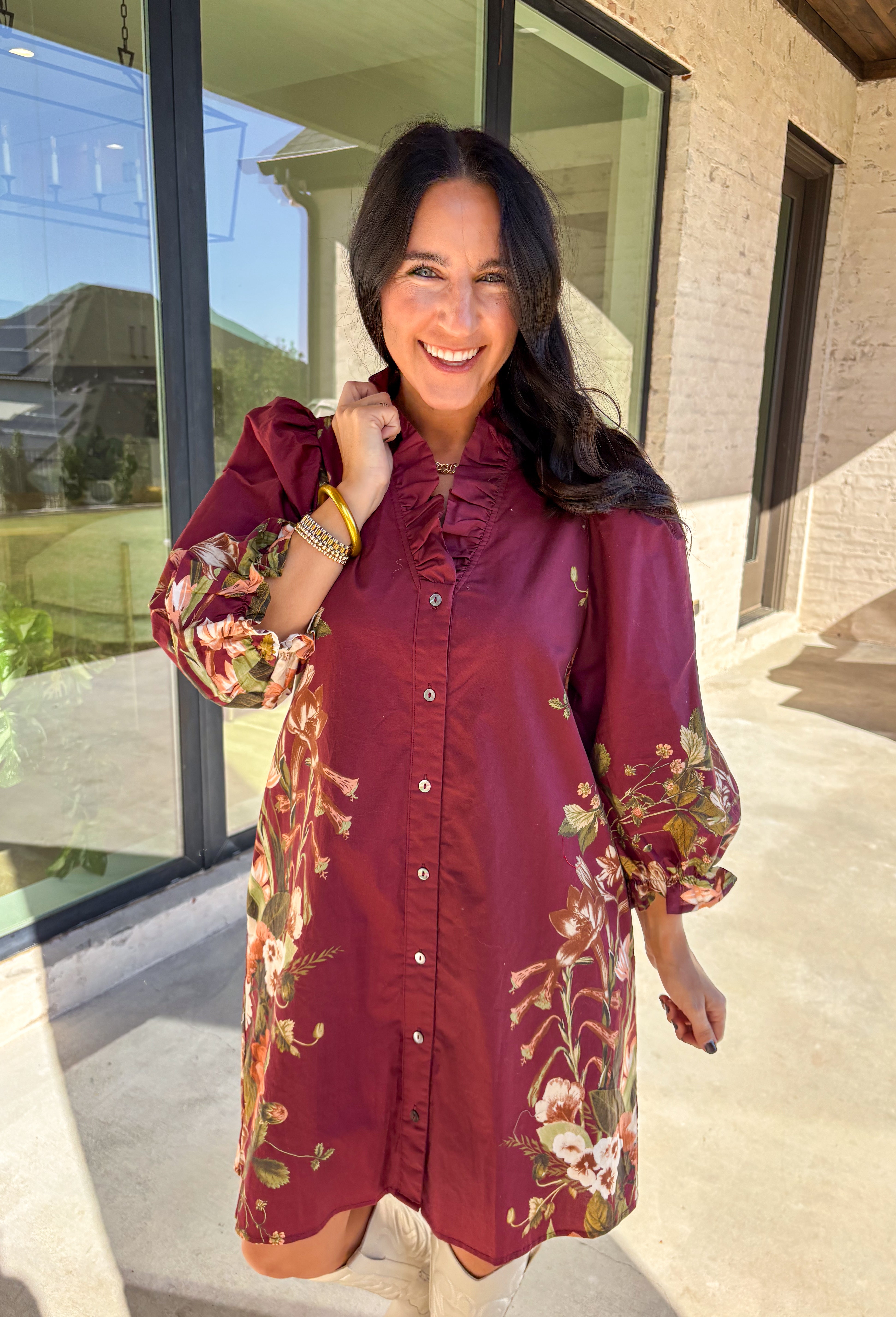 This burgundy button-down dress by Entro is a timeless piece with a fall-ready twist. Featuring a delicate floral print along the sides, it’s designed with a ruffled accent v-neckline for a touch of femininity. The elastic sleeves make for an easy, comfortable fit, while the full lining ensures effortless wear. With its rich color and flattering silhouette, this dress transitions seamlessly from day to night.