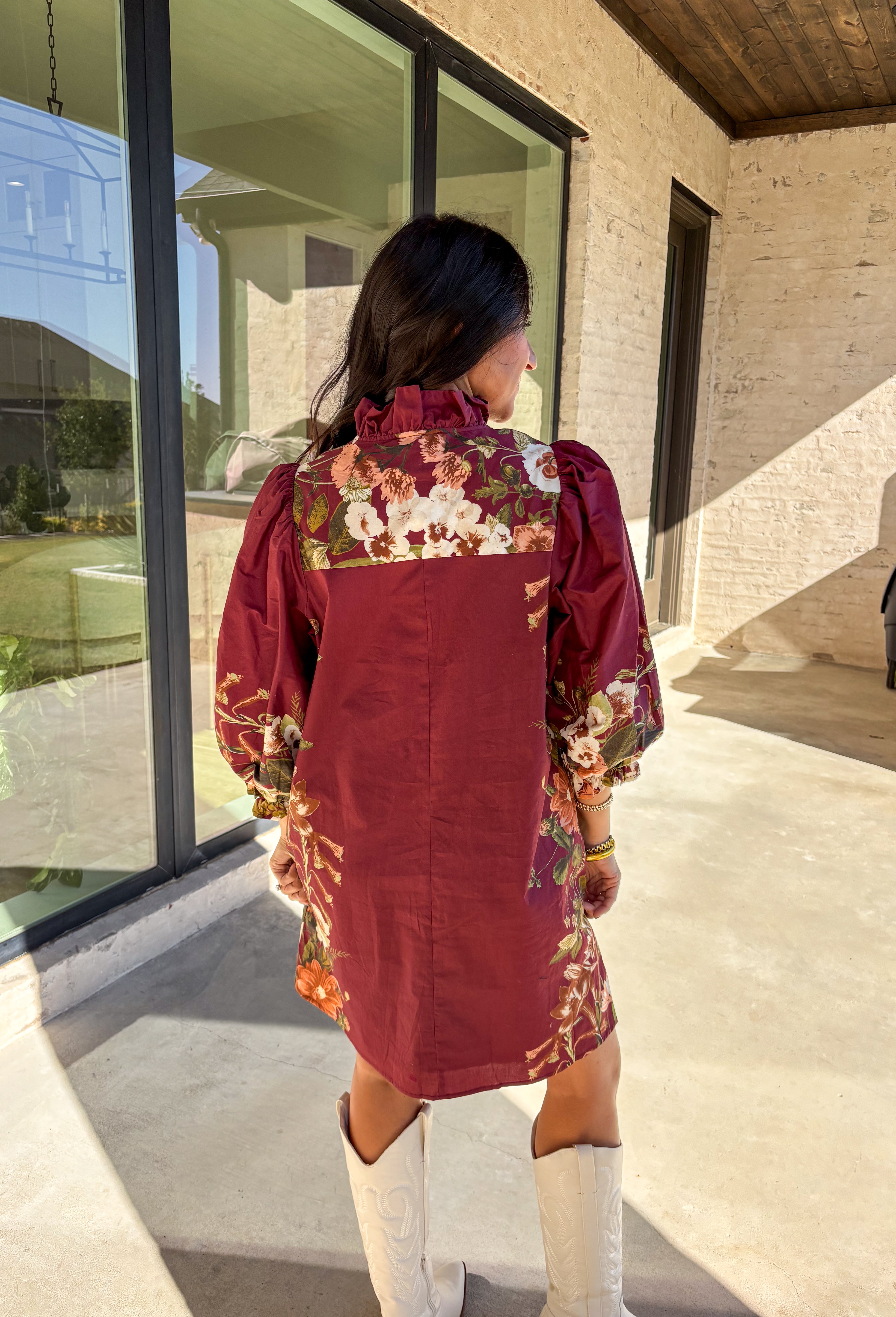 This burgundy button-down dress by Entro is a timeless piece with a fall-ready twist. Featuring a delicate floral print along the sides, it’s designed with a ruffled accent v-neckline for a touch of femininity. The elastic sleeves make for an easy, comfortable fit, while the full lining ensures effortless wear. With its rich color and flattering silhouette, this dress transitions seamlessly from day to night.