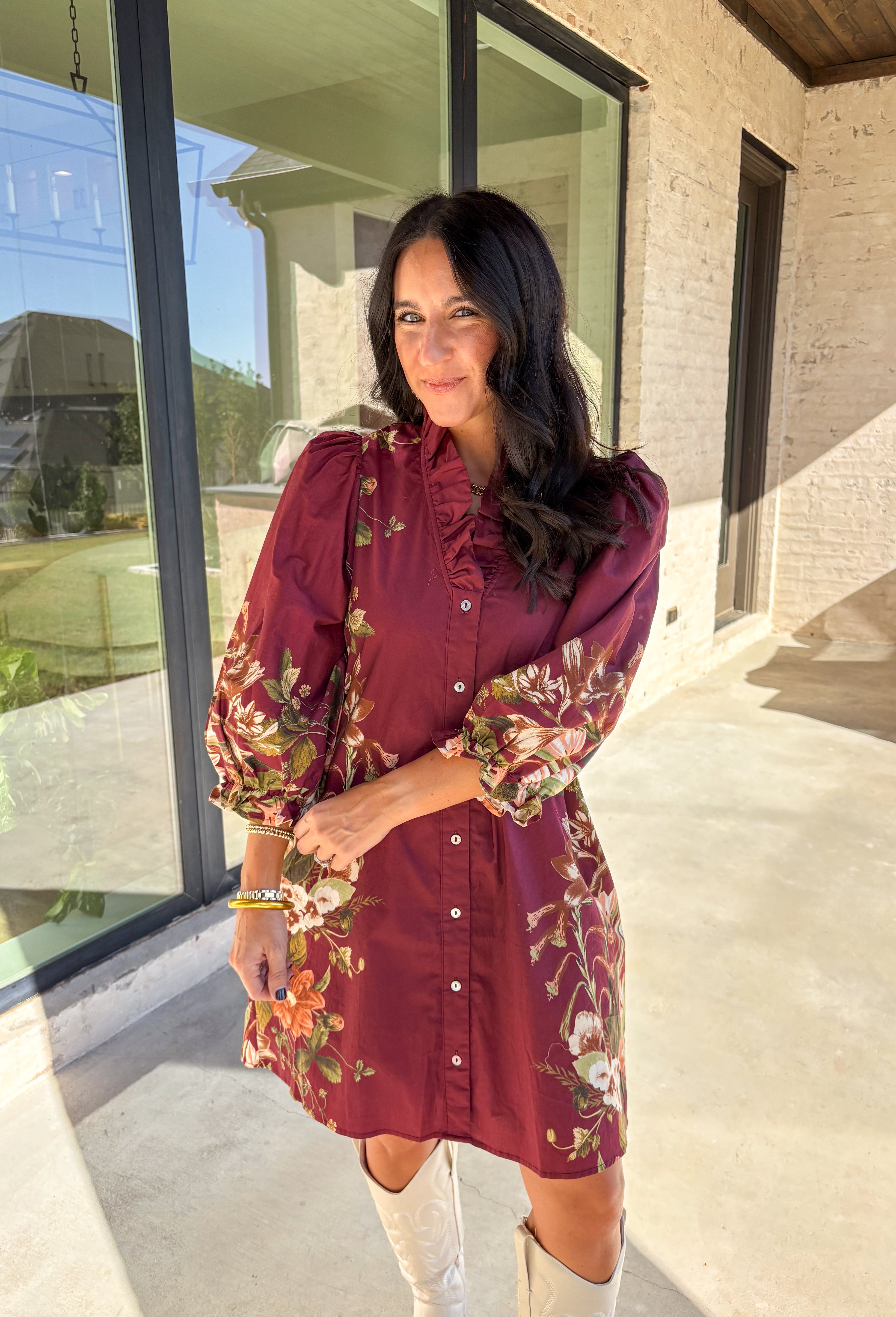 This burgundy button-down dress by Entro is a timeless piece with a fall-ready twist. Featuring a delicate floral print along the sides, it’s designed with a ruffled accent v-neckline for a touch of femininity. The elastic sleeves make for an easy, comfortable fit, while the full lining ensures effortless wear. With its rich color and flattering silhouette, this dress transitions seamlessly from day to night.