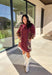 This burgundy button-down dress by Entro is a timeless piece with a fall-ready twist. Featuring a delicate floral print along the sides, it’s designed with a ruffled accent v-neckline for a touch of femininity. The elastic sleeves make for an easy, comfortable fit, while the full lining ensures effortless wear. With its rich color and flattering silhouette, this dress transitions seamlessly from day to night.