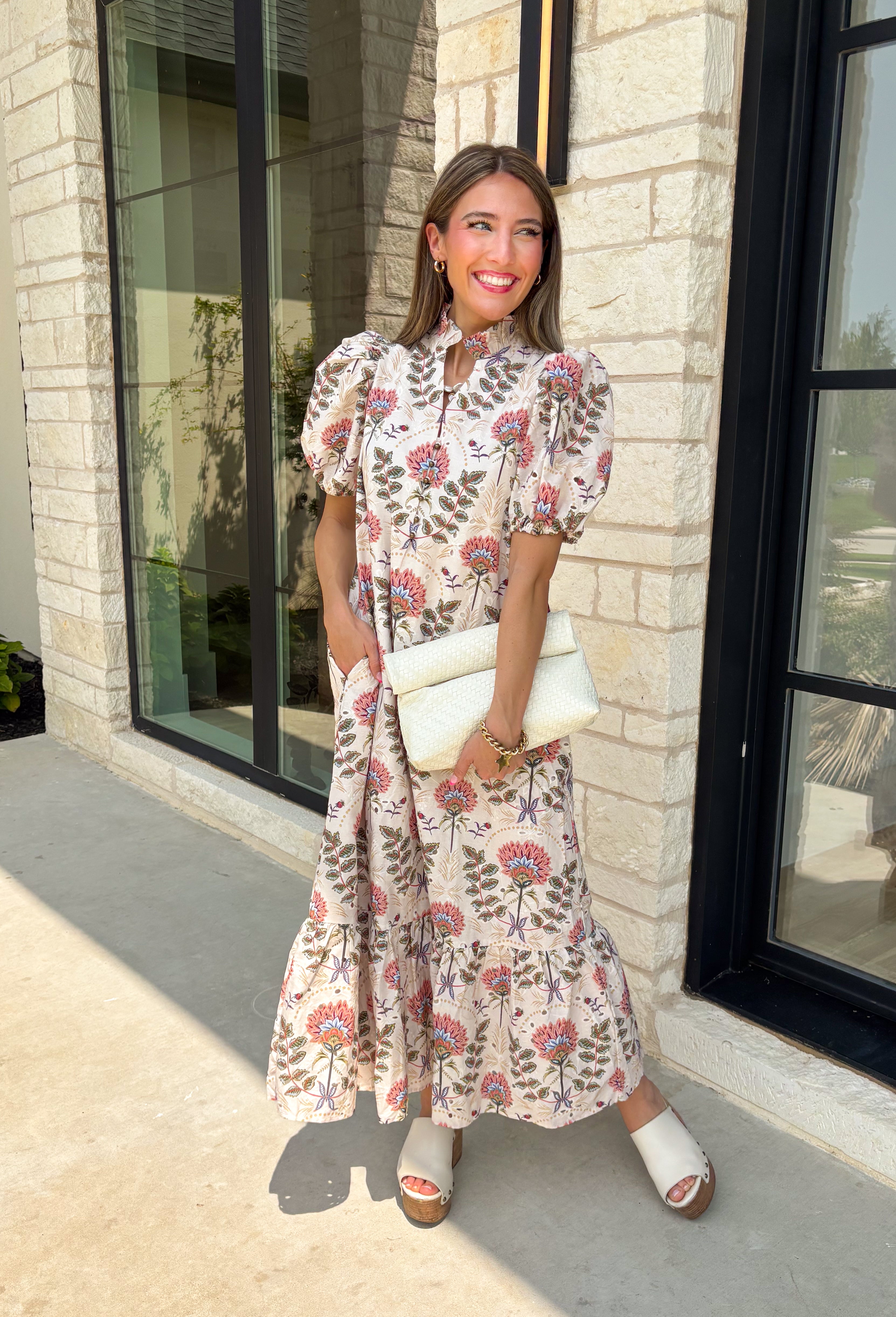 Effortlessly feminine and timelessly beautiful, this floral midi dress is a piece you'll love wearing from the first crisp days of fall through the holiday season. Designed with a rich navy backdrop and adorned with an olive and brown floral print, it captures the warm, earthy tones of autumn while remaining classic enough to wear year after year. The ruffled neckline, puff sleeves, and button-front details create a polished silhouette.
