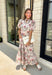 Effortlessly feminine and timelessly beautiful, this floral midi dress is a piece you'll love wearing from the first crisp days of fall through the holiday season. Designed with a rich navy backdrop and adorned with an olive and brown floral print, it captures the warm, earthy tones of autumn while remaining classic enough to wear year after year. The ruffled neckline, puff sleeves, and button-front details create a polished silhouette.