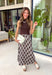 Elevate your fall wardrobe with this effortlessly elegant midi dress from Skies Are Blue. Featuring a rich brown sleeveless knit bodice with a classic mock neckline, this dress is beautifully complemented by a flowing pleated skirt showcasing an abstract print with subtle pops of blue. The combination of textures creates a polished, sophisticated look that's both comfortable and eye-catching. 