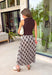 Elevate your fall wardrobe with this effortlessly elegant midi dress from Skies Are Blue. Featuring a rich brown sleeveless knit bodice with a classic mock neckline, this dress is beautifully complemented by a flowing pleated skirt showcasing an abstract print with subtle pops of blue. The combination of textures creates a polished, sophisticated look that's both comfortable and eye-catching. 