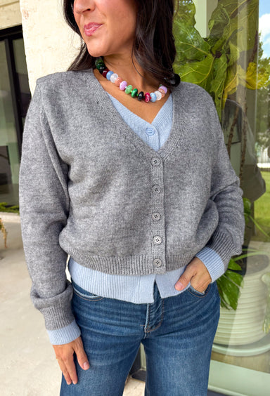 Get the perfectly layered look without any extra effort. This cozy cardigan is designed with a built-in layered effect, featuring a soft grey button-front sweater paired with the look of a blue button-down knit underneath for an effortlessly polished style. Finished with ribbed trim for a classic touch, this sweater gives you the appearance of layering while keeping your outfit comfortable and easy to wear. It's the perfect grab-and-go piece for workdays, weekend outings, and everything in between.