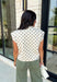 Classic polka dots get a cozy fall makeover in this adorable sleeveless sweater. Featuring a soft ecru knit with rich brown polka dots, this timeless top is equal parts playful and polished. The mock neckline and cap sleeve detail create an elevated silhouette, while the soft sweater knit makes it perfect for layering throughout the season. Wear it on its own during mild autumn days or layer it under your favorite jacket or blazer as the temperatures begin to cool.