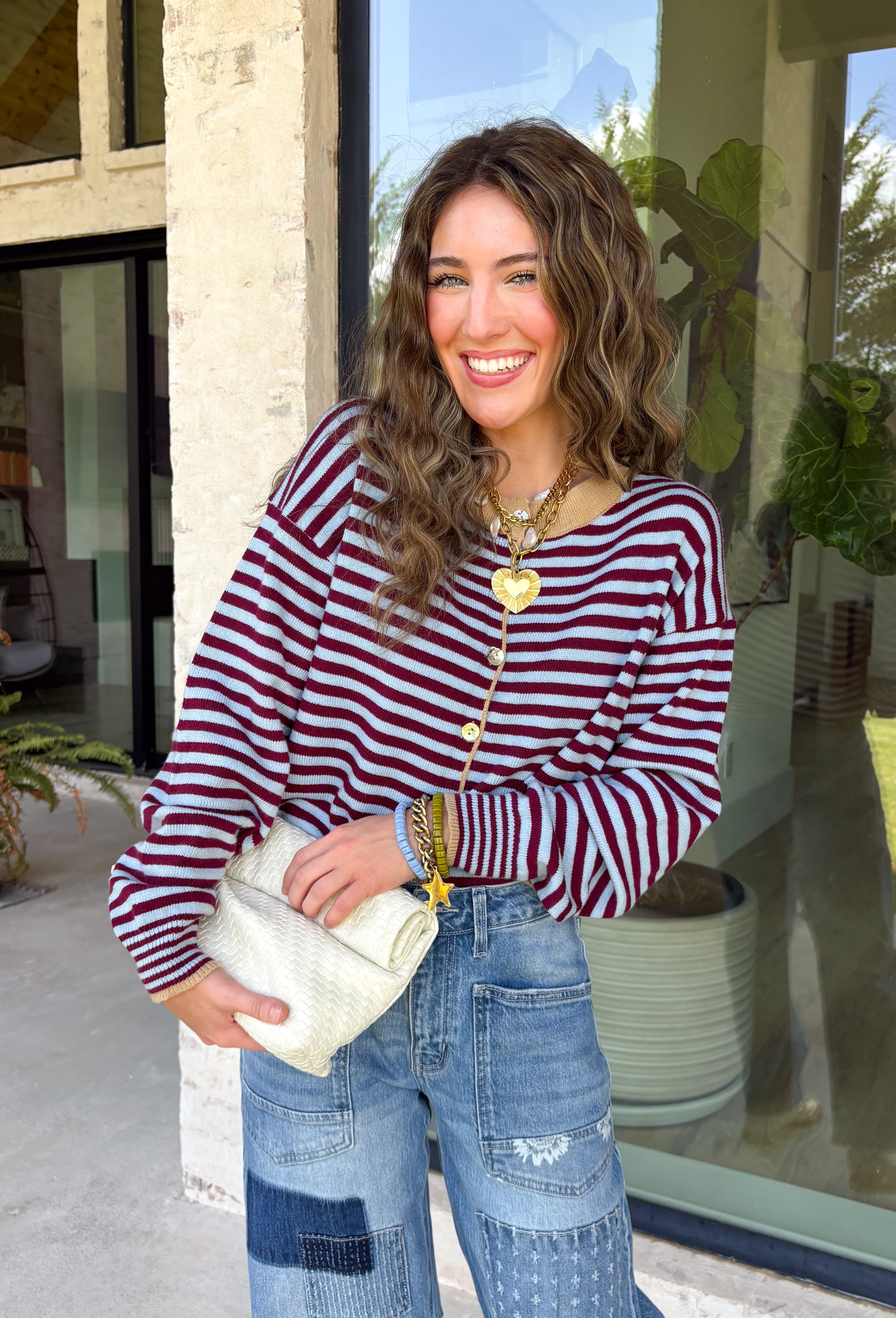 Rich fall colors come together beautifully in this cozy striped cardigan! Featuring burgundy and light blue stripes accented with warm tan trim, this timeless knit adds the perfect pop of seasonal color to any outfit. The button-down front offers endless styling options, while the ribbed neckline gives it a classic finish. Soft, lightweight, and easy to layer, this cardigan is perfect for everything from office days and coffee dates to football weekends and crisp autumn afternoons.