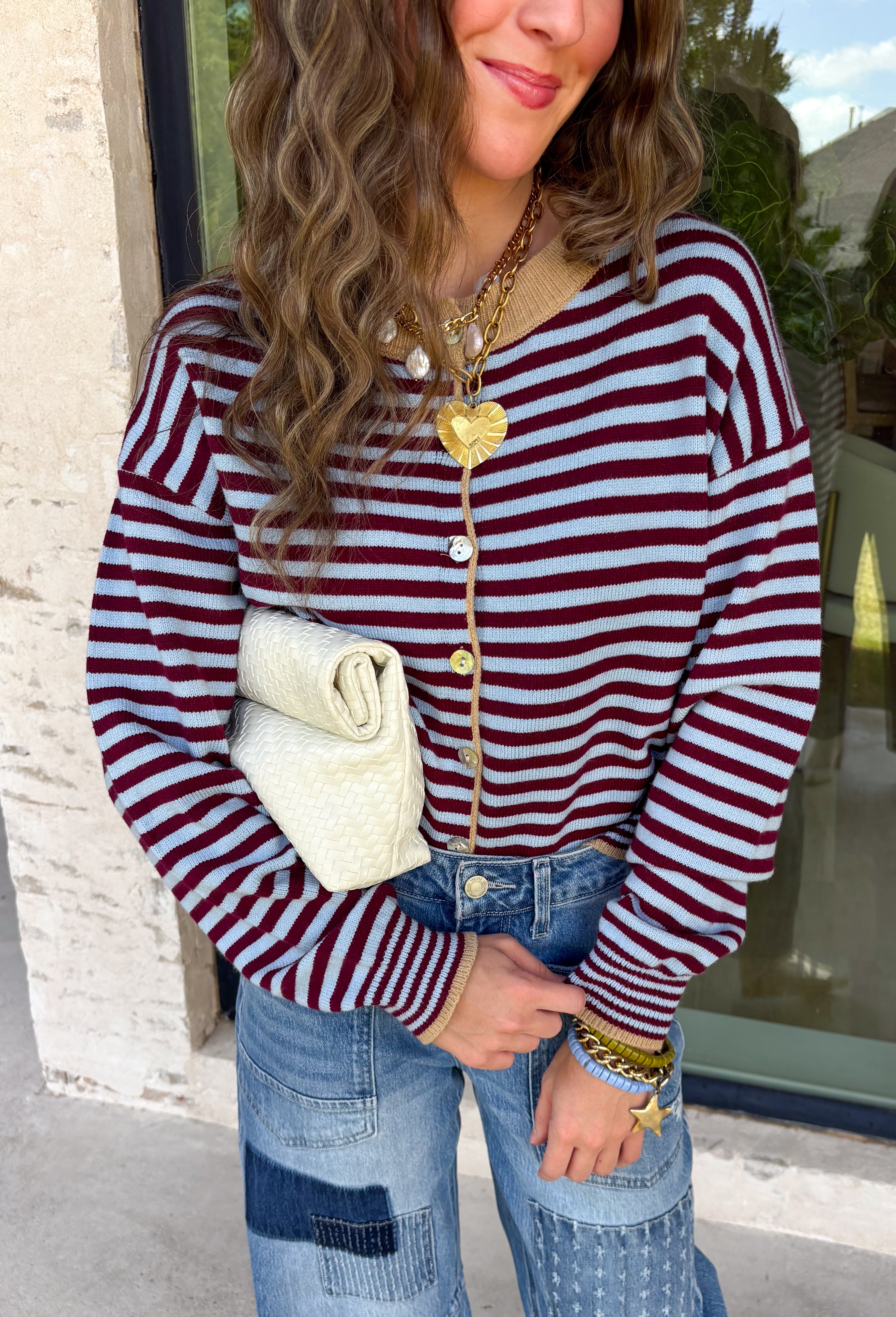 Rich fall colors come together beautifully in this cozy striped cardigan! Featuring burgundy and light blue stripes accented with warm tan trim, this timeless knit adds the perfect pop of seasonal color to any outfit. The button-down front offers endless styling options, while the ribbed neckline gives it a classic finish. Soft, lightweight, and easy to layer, this cardigan is perfect for everything from office days and coffee dates to football weekends and crisp autumn afternoons.
