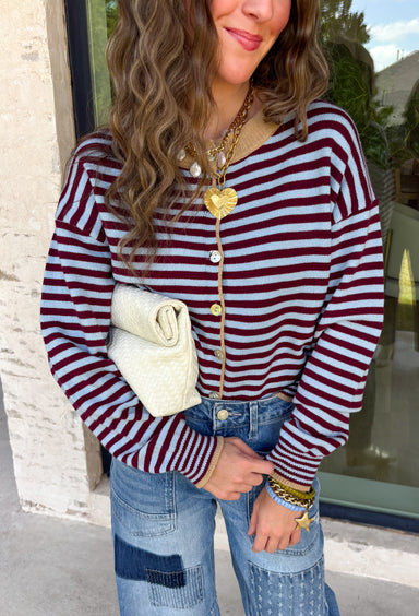 Rich fall colors come together beautifully in this cozy striped cardigan! Featuring burgundy and light blue stripes accented with warm tan trim, this timeless knit adds the perfect pop of seasonal color to any outfit. The button-down front offers endless styling options, while the ribbed neckline gives it a classic finish. Soft, lightweight, and easy to layer, this cardigan is perfect for everything from office days and coffee dates to football weekends and crisp autumn afternoons.