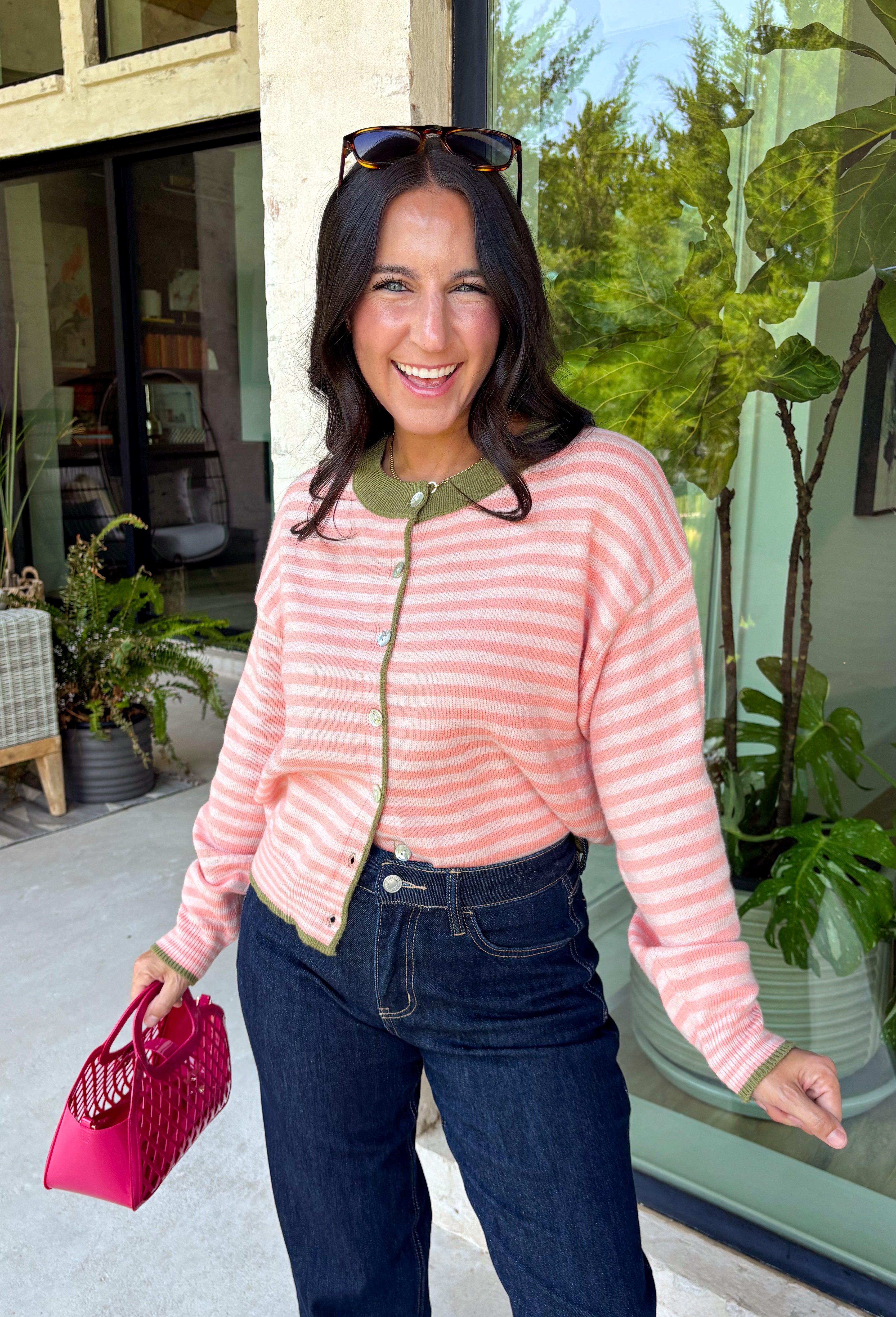 Bright colors come together beautifully in this cozy striped cardigan! Featuring pink and salmon stripes accented with an olive trim, this timeless knit adds the perfect pop of seasonal color to any outfit. The button-down front offers endless styling options, while the ribbed neckline gives it a classic finish. Soft, lightweight, and easy to layer, this cardigan is perfect for everything from office days and coffee dates to football weekends and crisp autumn afternoons.