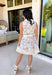 Soft, timeless, and perfect for spring days, this sleeveless tan dress is an effortless go-to for looking put together with minimal effort. Featuring a white floral print throughout, it has a fresh, neutral feel that’s easy to dress up or keep casual. The hidden button-down design and collared neckline give it a classic touch, while white trim along the front adds a clean contrast detail. 