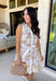 Soft, timeless, and perfect for spring days, this sleeveless tan dress is an effortless go-to for looking put together with minimal effort. Featuring a white floral print throughout, it has a fresh, neutral feel that’s easy to dress up or keep casual. The hidden button-down design and collared neckline give it a classic touch, while white trim along the front adds a clean contrast detail. 
