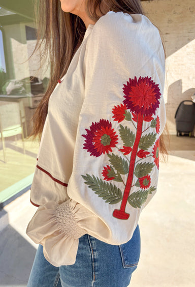 This ecru long sleeve top by Entro is the perfect blend of cozy neutrals and fall charm. Designed with puff sleeves and beautiful floral embroidery, it adds a soft, feminine touch to any outfit. The contrast piping at the neckline and waist gives it a flattering shape, while the smocked cuffs with ruffle edges add a sweet finishing detail. Effortless and chic, this top transitions perfectly from weekday wear to weekend outings.