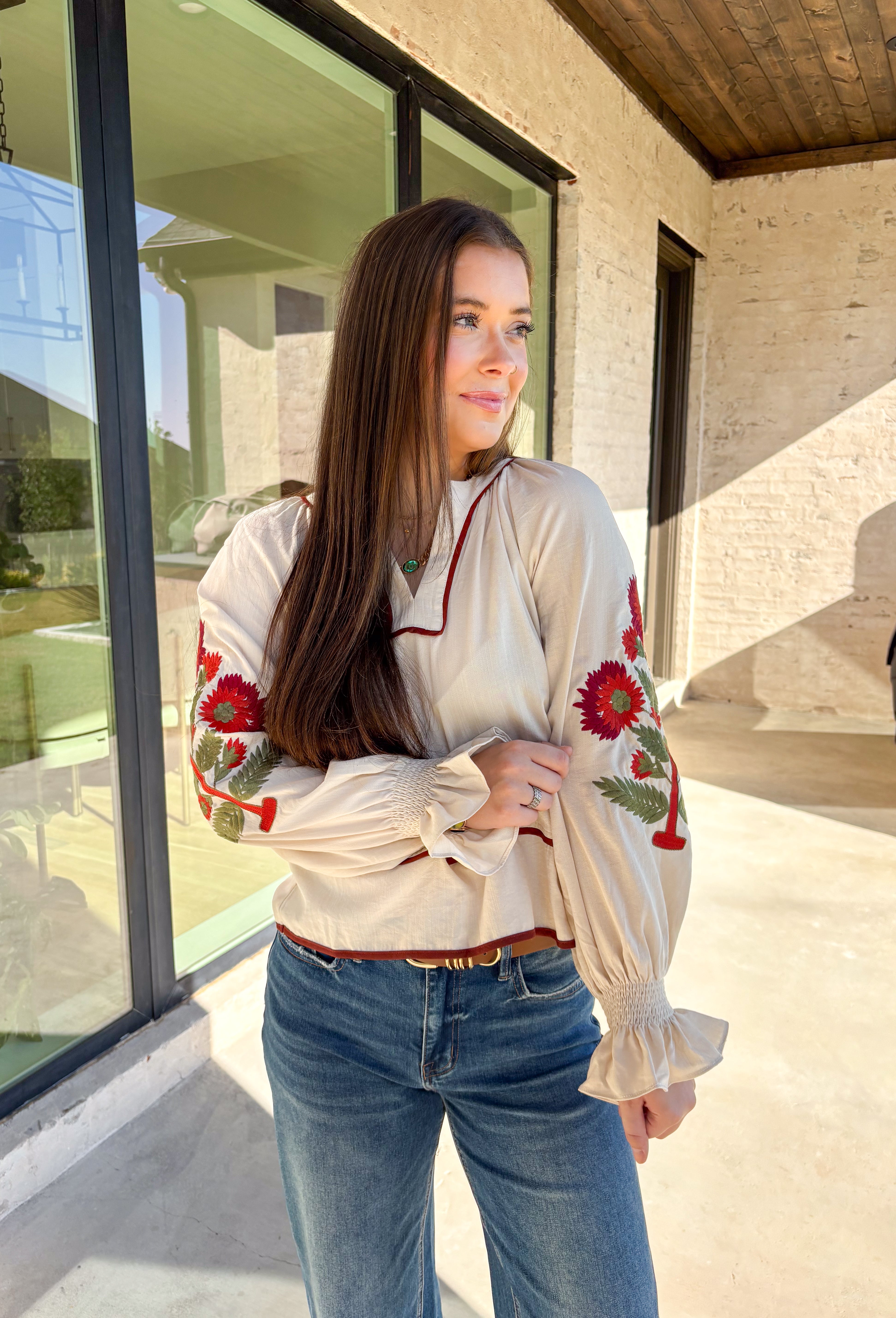 This ecru long sleeve top by Entro is the perfect blend of cozy neutrals and fall charm. Designed with puff sleeves and beautiful floral embroidery, it adds a soft, feminine touch to any outfit. The contrast piping at the neckline and waist gives it a flattering shape, while the smocked cuffs with ruffle edges add a sweet finishing detail. Effortless and chic, this top transitions perfectly from weekday wear to weekend outings.