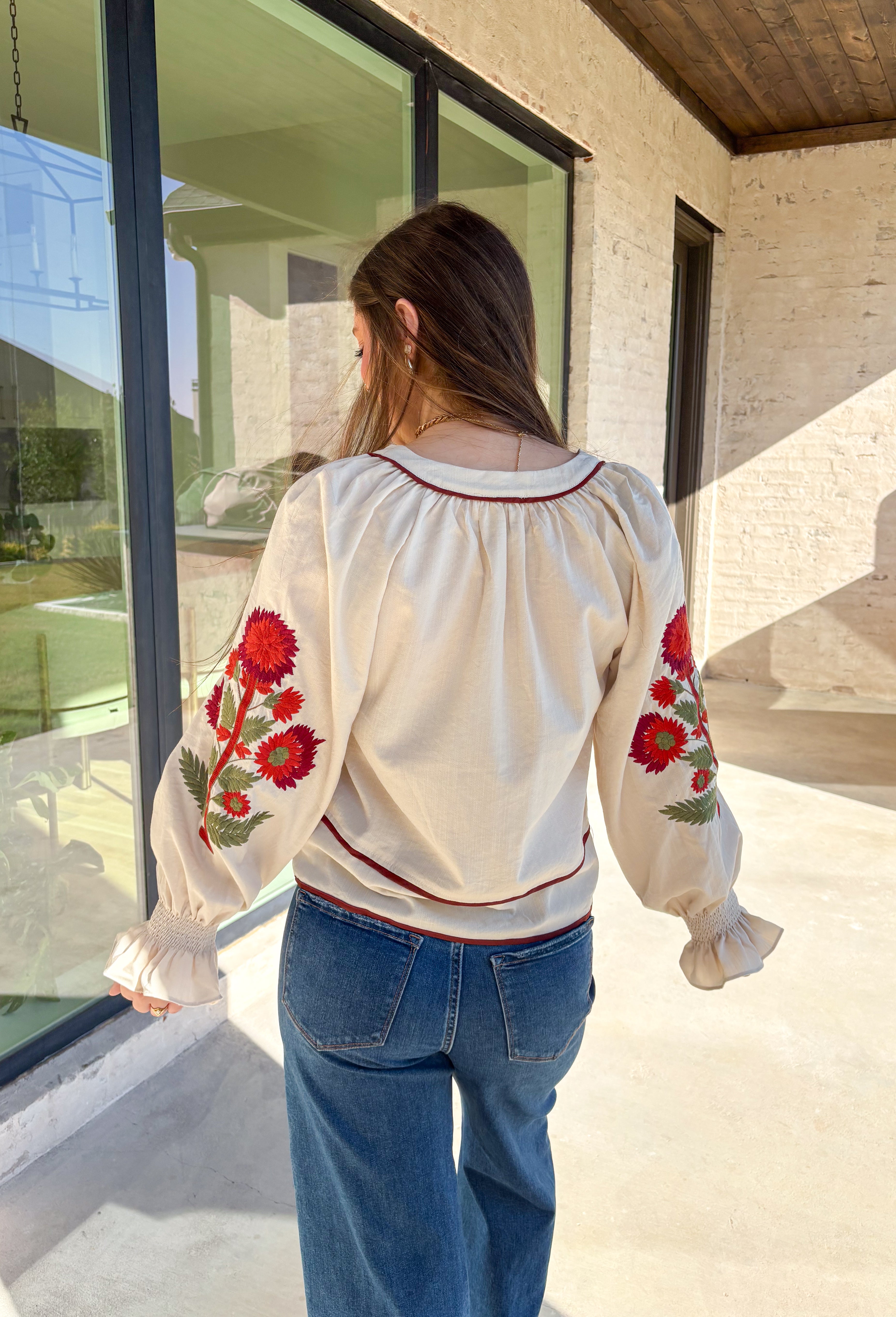 This ecru long sleeve top by Entro is the perfect blend of cozy neutrals and fall charm. Designed with puff sleeves and beautiful floral embroidery, it adds a soft, feminine touch to any outfit. The contrast piping at the neckline and waist gives it a flattering shape, while the smocked cuffs with ruffle edges add a sweet finishing detail. Effortless and chic, this top transitions perfectly from weekday wear to weekend outings.