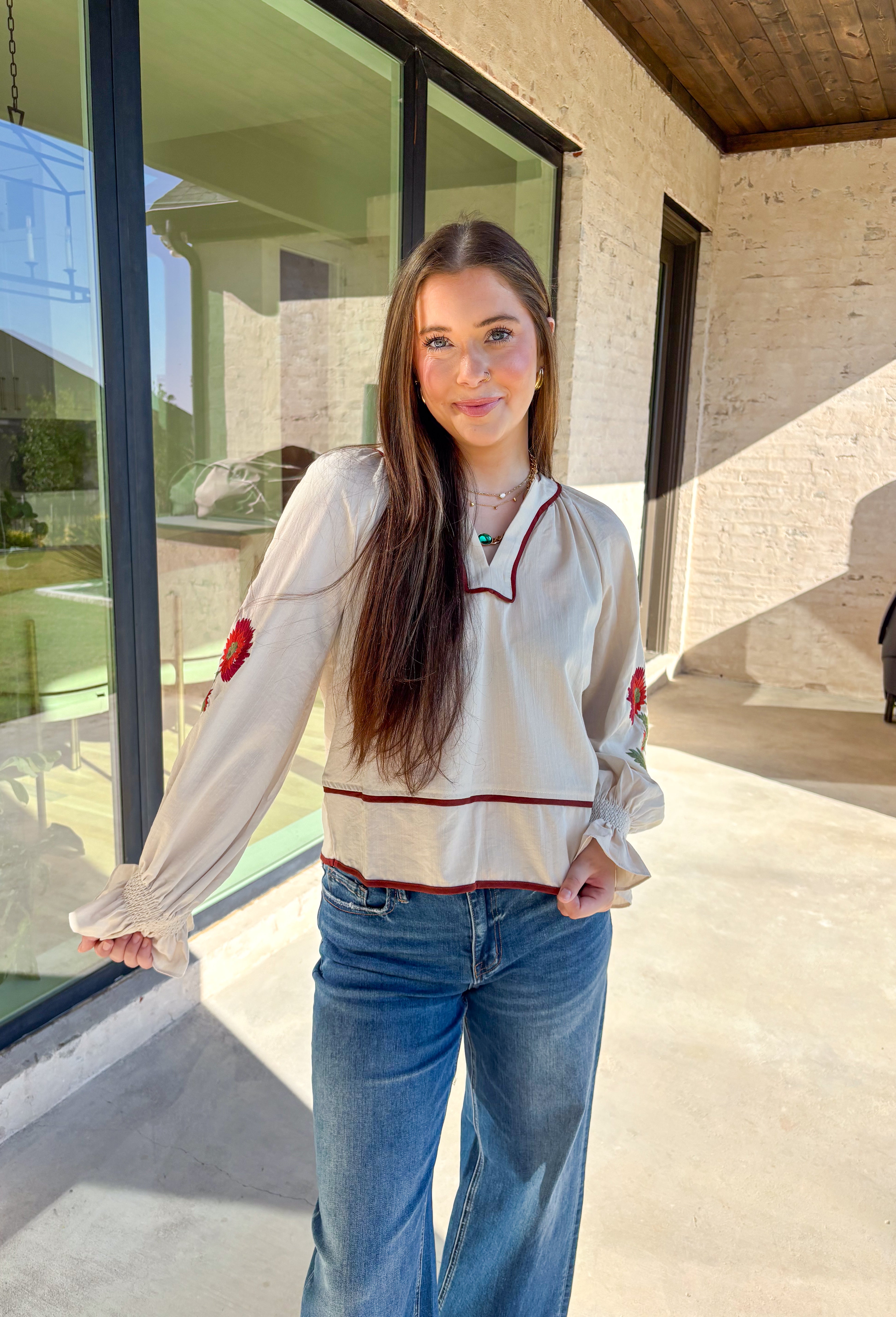 This ecru long sleeve top by Entro is the perfect blend of cozy neutrals and fall charm. Designed with puff sleeves and beautiful floral embroidery, it adds a soft, feminine touch to any outfit. The contrast piping at the neckline and waist gives it a flattering shape, while the smocked cuffs with ruffle edges add a sweet finishing detail. Effortless and chic, this top transitions perfectly from weekday wear to weekend outings.