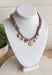 Playful and trendy, this tan bandana necklace is full of personality. Detailed with a mix of eclectic charms—including a sparkling crystal star, gold bow, pearls, gold pendant, gold heart, and a gold cowboy boot—it’s the perfect statement piece to add fun flair to any outfit. With a 16" length and 3" extender, you can adjust it to layer with other necklaces or let it shine on its own. A must-have for adding a pop of charm to your wardrobe.