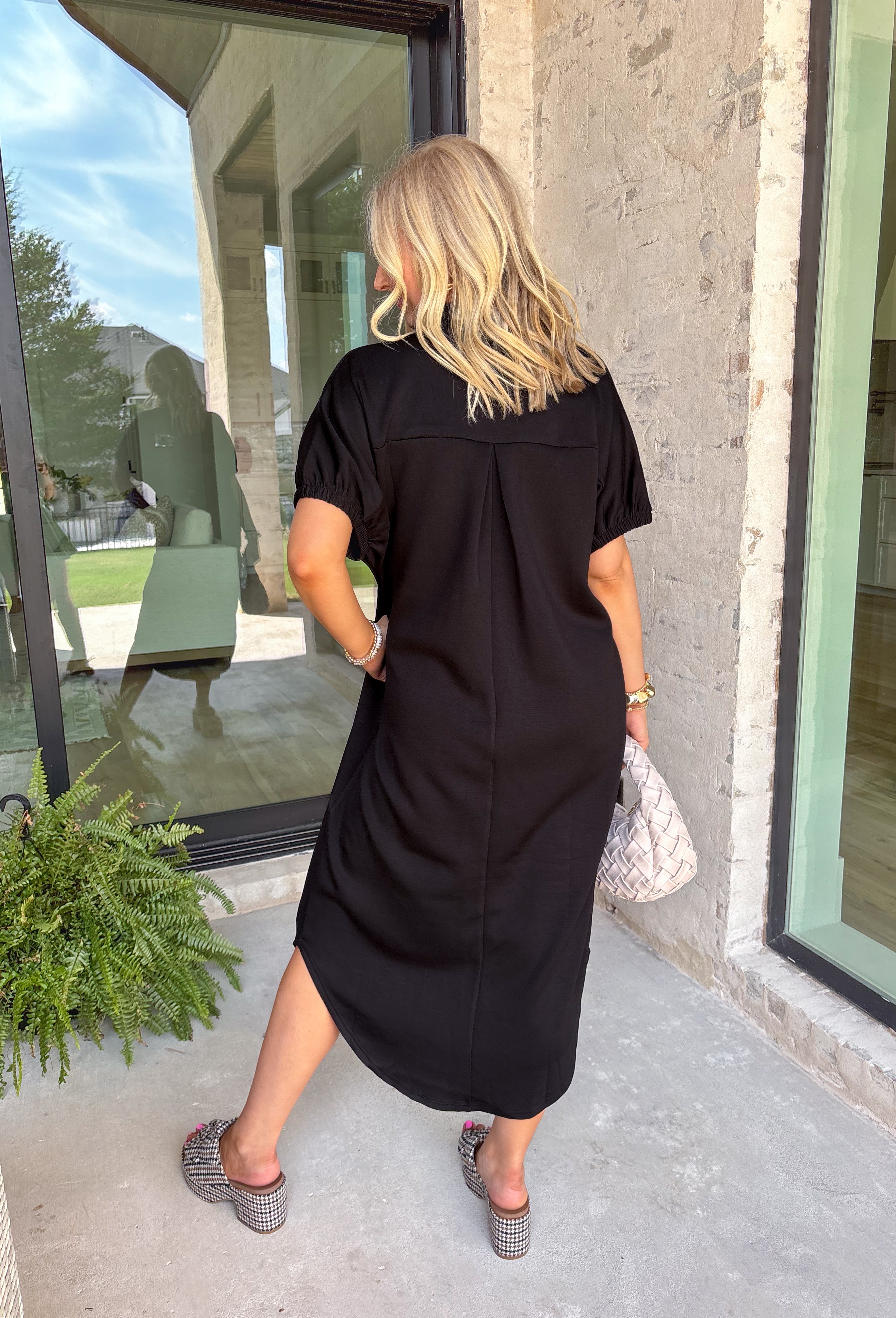 Effortless and versatile, this black midi dress is an easy favorite for fall. Designed with a band collar v-neckline and elasticated short sleeves, it offers both structure and comfort. Side pockets keep it practical, while the soft, stretchy fabric blend makes it perfect for all-day wear. You'll find yourself reaching for this dress all season long!
