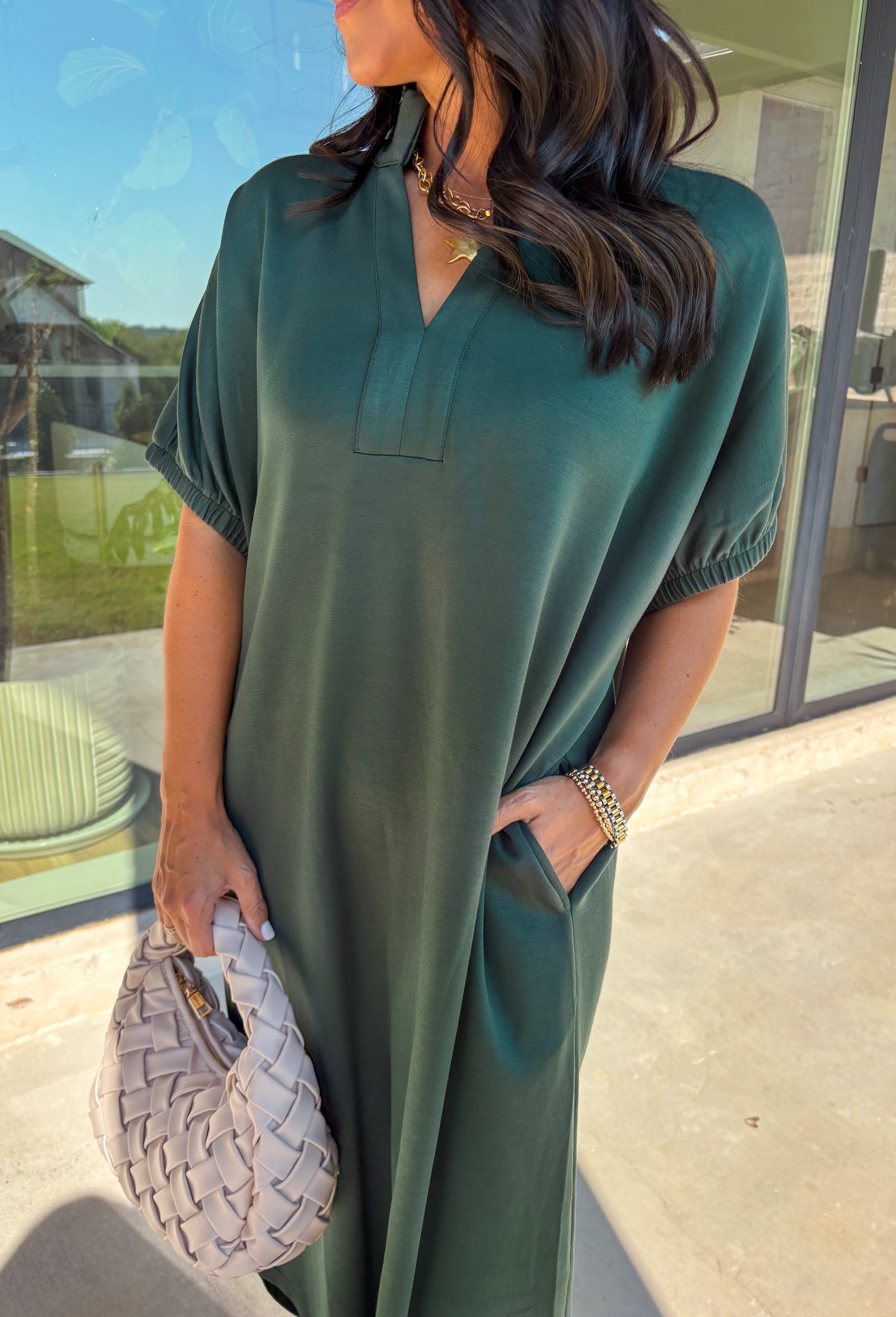 Effortless and versatile, this forest green midi dress is an easy favorite for fall. Designed with a band collar v-neckline and elasticated short sleeves, it offers both structure and comfort. Side pockets keep it practical, while the soft, stretchy fabric blend makes it perfect for all-day wear. You'll find yourself reaching for this dress all season long!