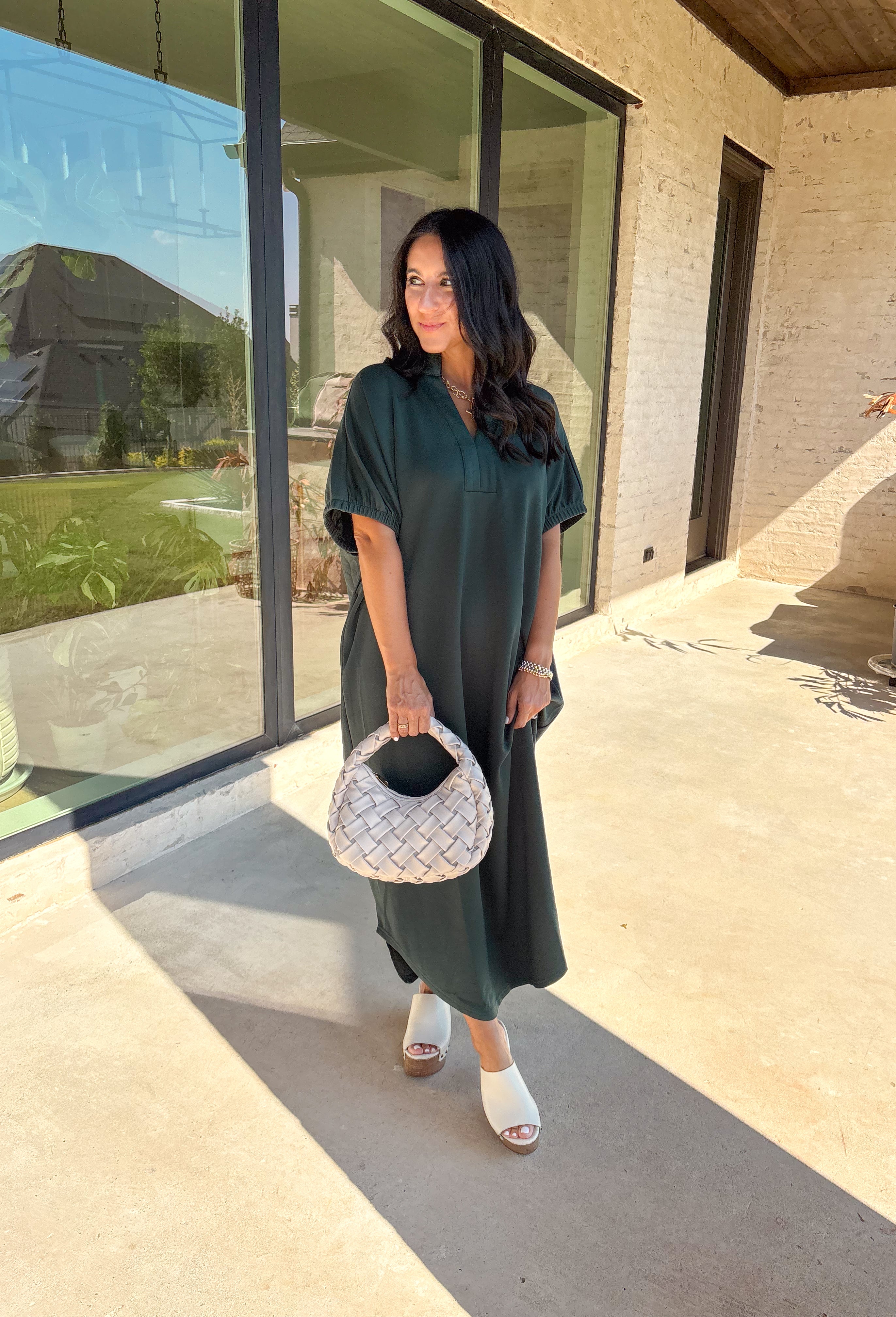 Effortless and versatile, this forest green midi dress is an easy favorite for fall. Designed with a band collar v-neckline and elasticated short sleeves, it offers both structure and comfort. Side pockets keep it practical, while the soft, stretchy fabric blend makes it perfect for all-day wear. You'll find yourself reaching for this dress all season long!